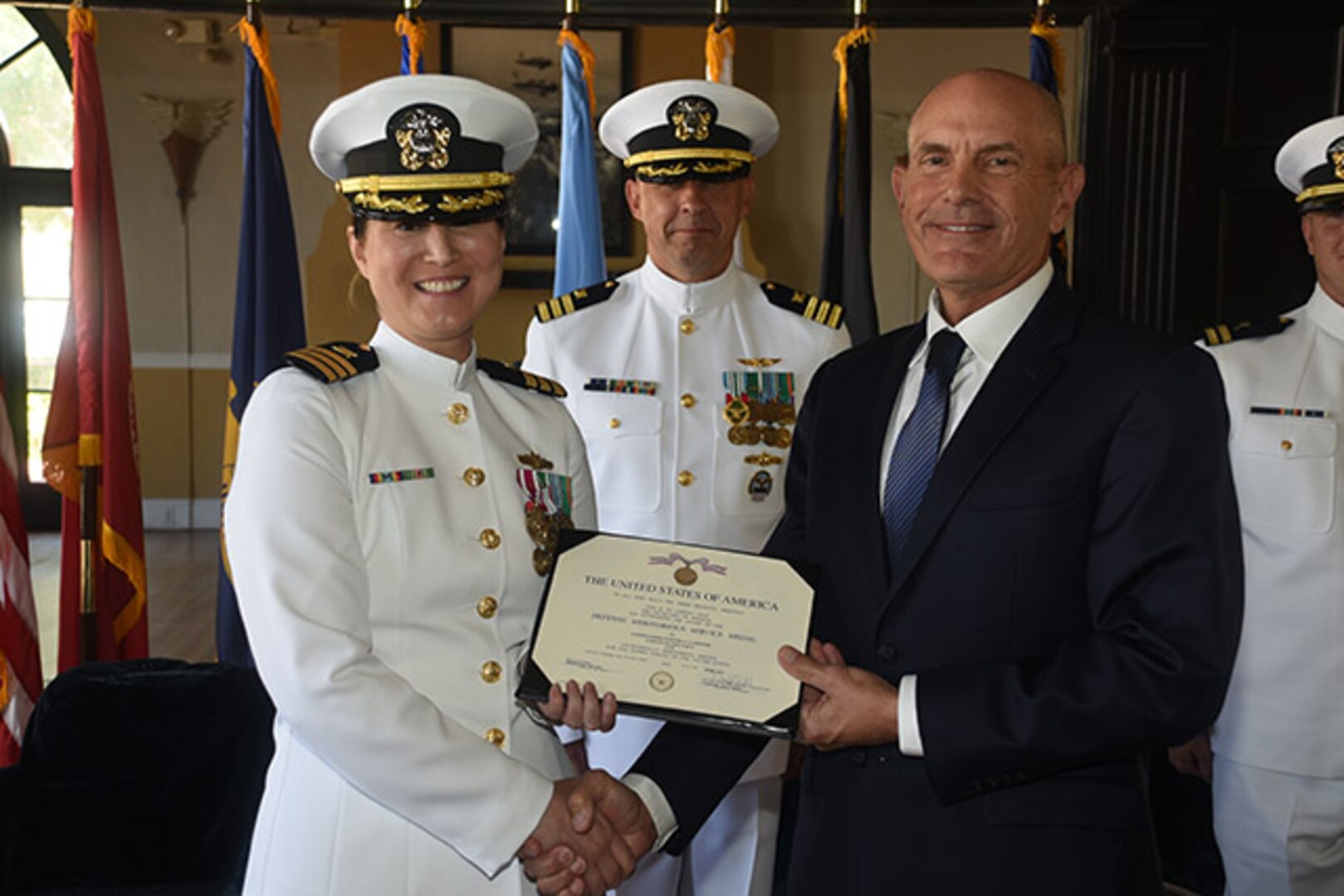 DLA Aviation Deputy Commander Charlie Lilli presents Navy Cmdr. Maxine Gardner with the Defense Meritorious Service Medal.