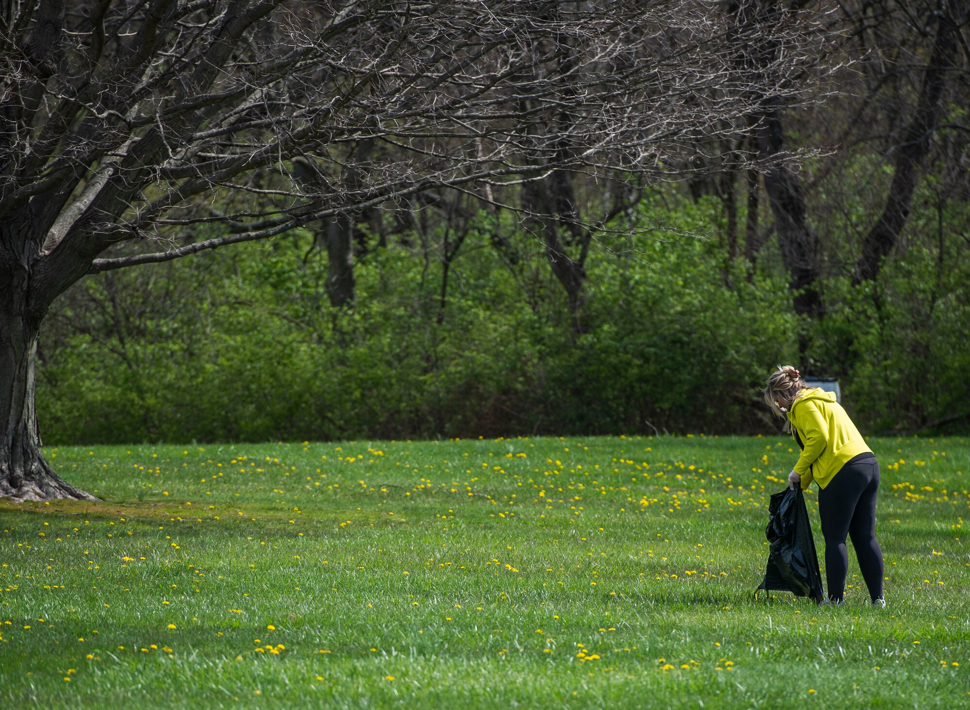 A volunteer picks up trash during an Earth Day event hosted by Wright-Patterson Air Force Base the City of Fairborn and the Beavercreek Wetlands Association at the Community Park in, Fairborn, Ohio, April 22, 2022. During the event volunteers picked up trash and debris in order to clean up the park. (U.S. Air Force photo by Wesley Farnsworth)