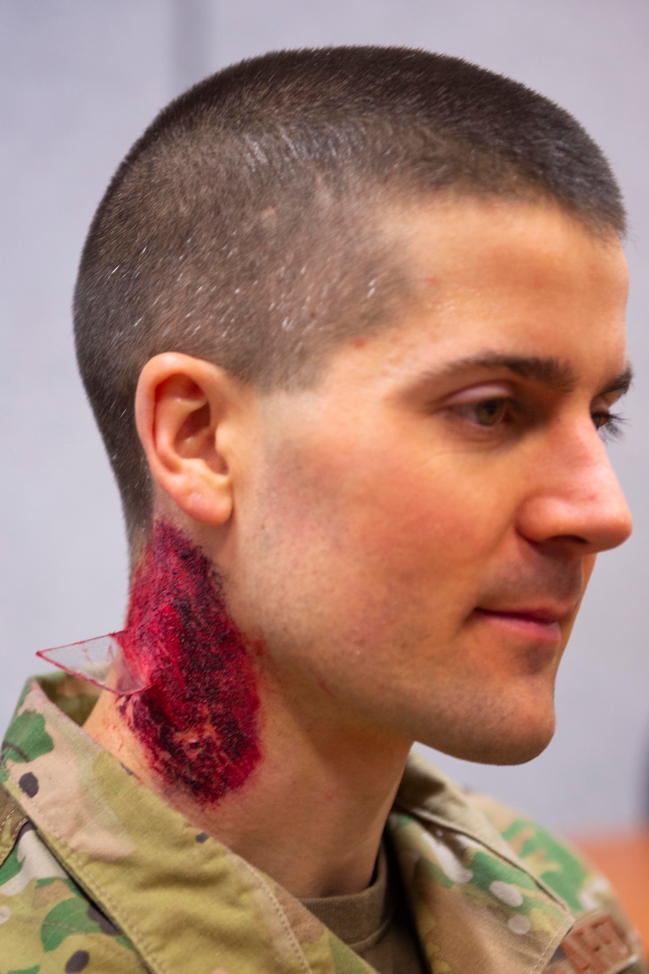 Cpt. Kyle Wall, a clinical nurse with the 934th Aeromedical Staging Squadron, has a mockup of a penetrating glass wound on his neck on April 7, 2022, at Volk Field Air National Guard Base, Wis. Wall and other Airmen had moulage applied to them for a simulated mass casualty training exercise supporting Viking Shield. (U.S. Air Force photo by Chris Farley)