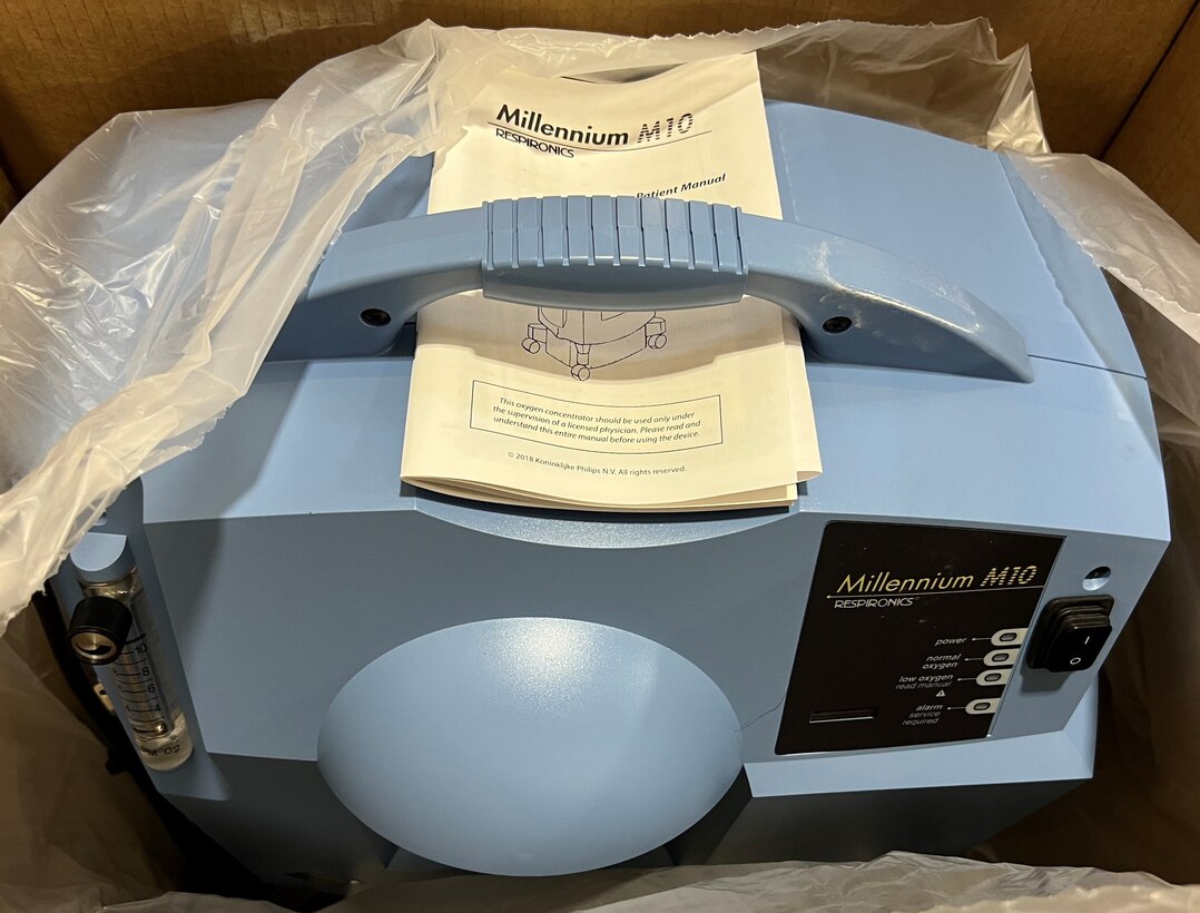An oxygen concentrator sits in an open box.