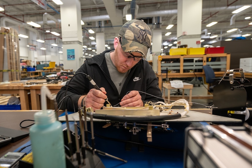 Photo of David Horvath soldering a six-position switch on a wiring harness.