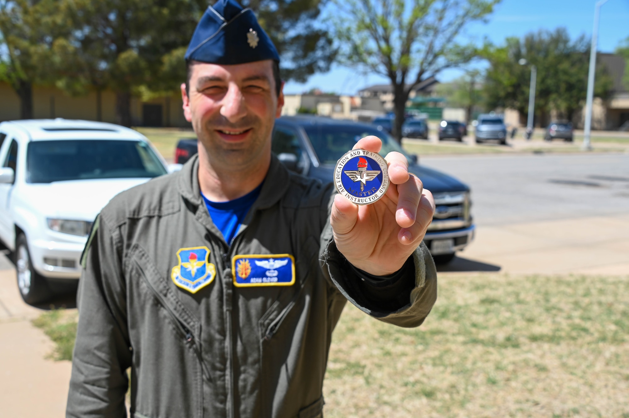 U.S. Air Force Lt. Col. Adam Glover, 97th Operations Group deputy commander, holds up a master instructor badge he received at Altus Air Force Base, Oklahoma, April 15, 2022. The master instructor badge is an award earned by the most proficient instructors to further recognize them. (U.S. Air Force photo by Senior Airman Kayla Christenson)