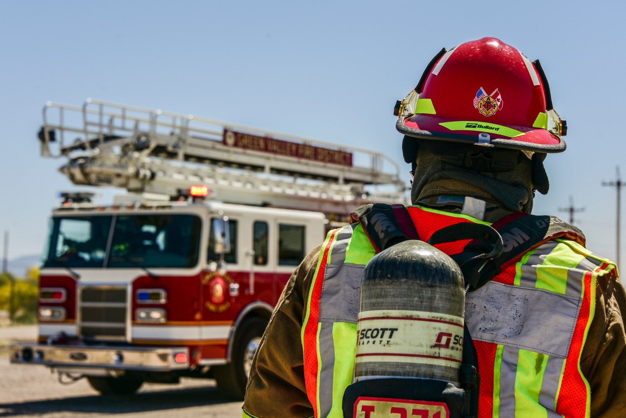 A photo of a firefighter and a fire truck.
