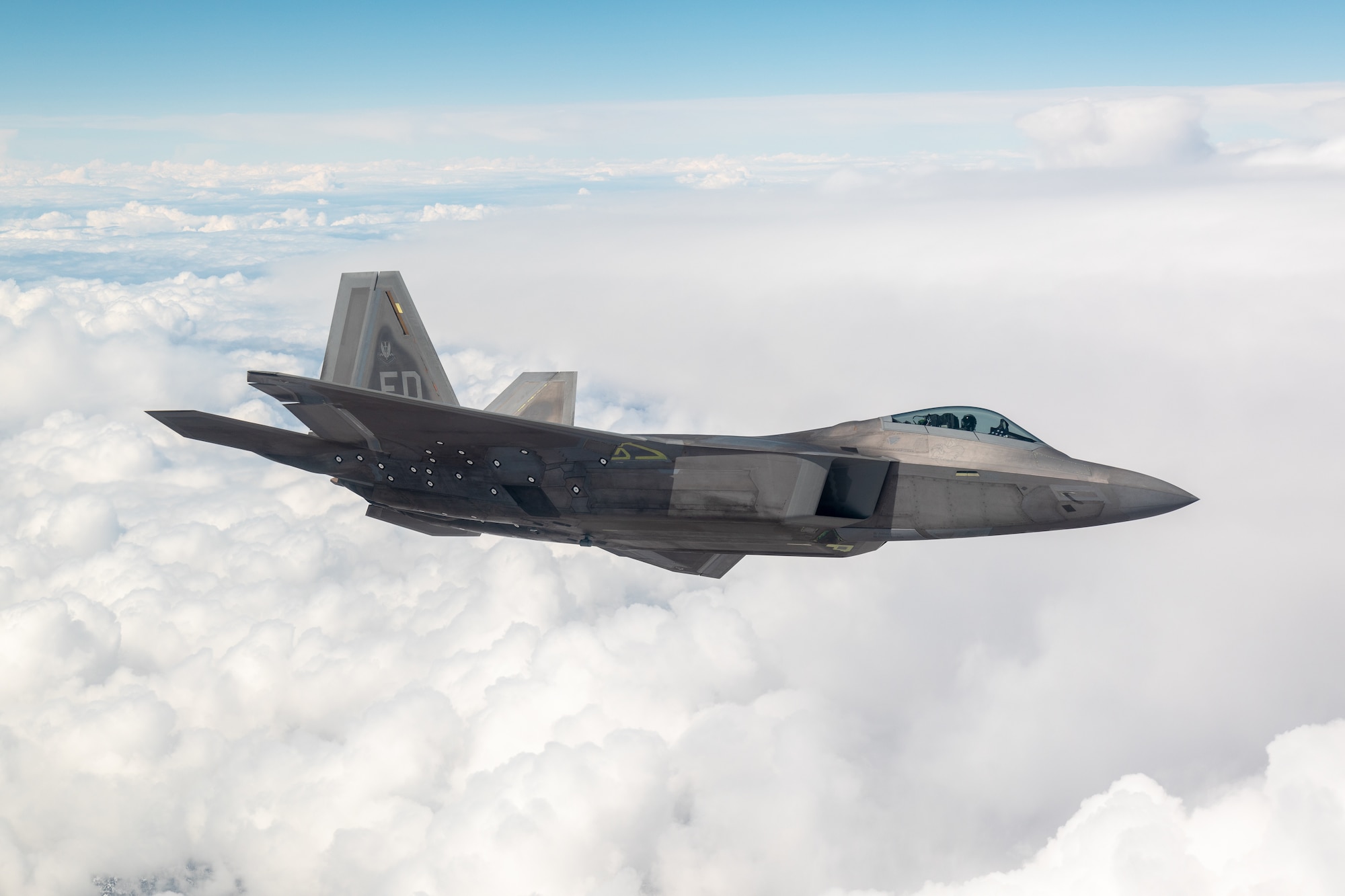 An F-22 Raptor flies above the clouds March 11, 2021. (Photo by Kyle Larson, Lockheed Martin)
