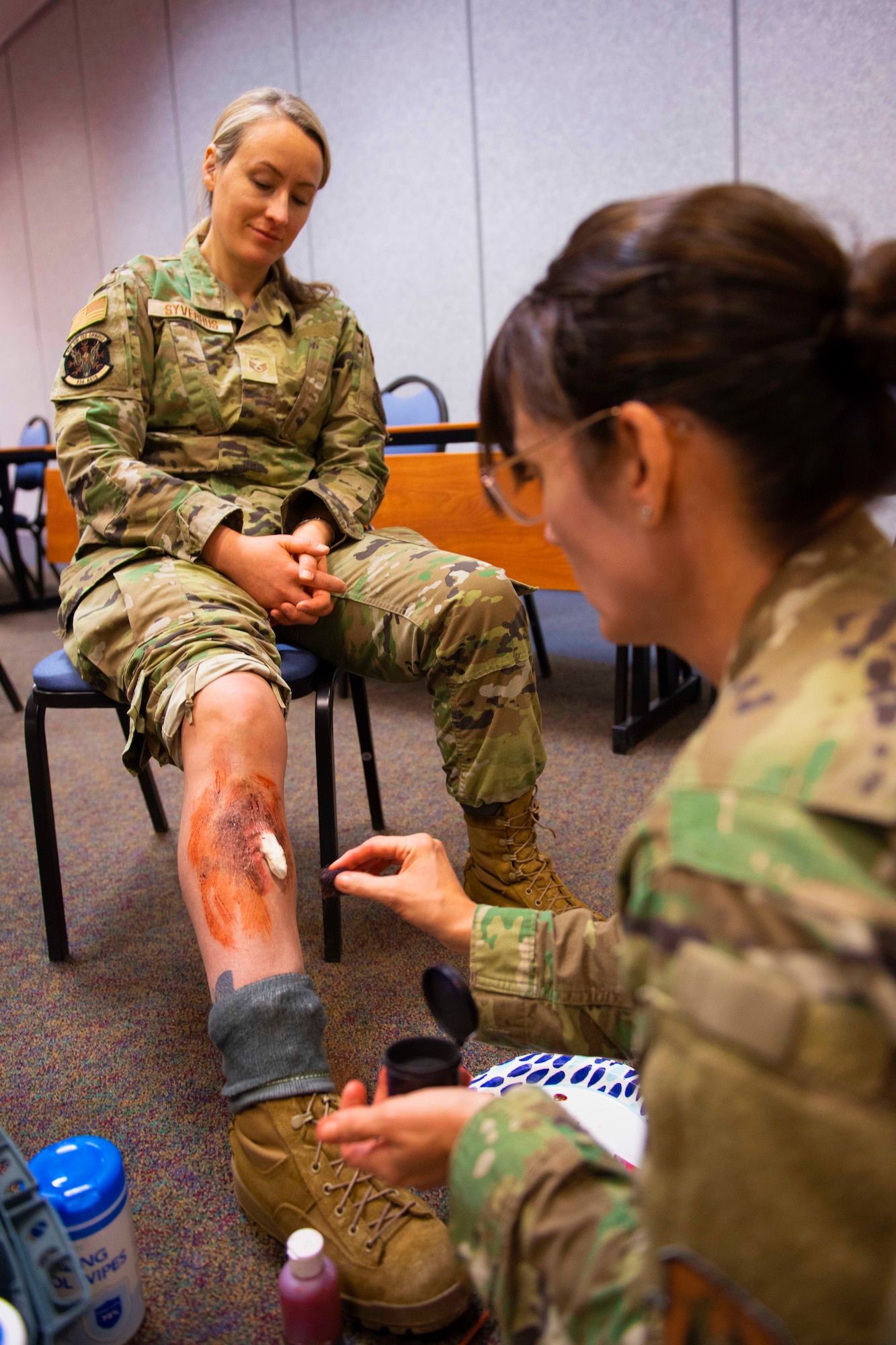 Staff Sgt. Sara Syverhus, 934th Aeromedical Staging Squadron medical technician, watches Maj. Deanna Jensen, a clinical nurse with the 934 ASTS, fashion her a compound leg fracture on April 7, 2022, at Volk Field Air National Guard Base, Wis. Syverhus and other Airmen had moulage applied to them for a simulated mass casualty training exercise supporting Viking Shield. (U.S. Air Force photo by Chris Farley)