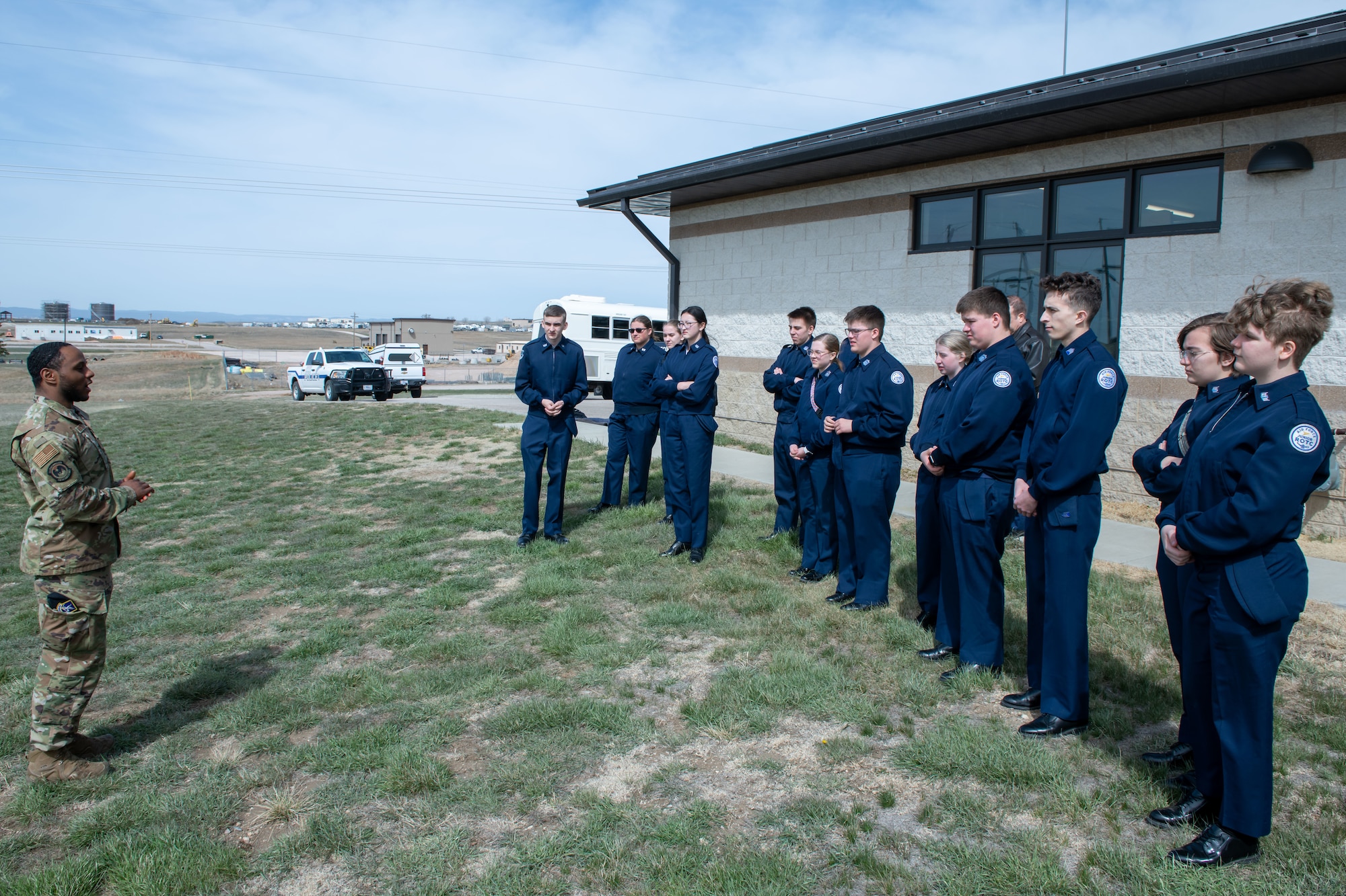 Students with the Douglas High School Air Force Junior Reserve Officer Training Corps view a demonstration from the Security Forces K-9 division on Ellsworth Air Force Base, S.D., April 19, 2022. K-9 handlers are security forces personnel that have received specialized training at Lackland Air Force Base, Texas. (U.S. Air Force Photo by Airman 1st Class Adam Olson)