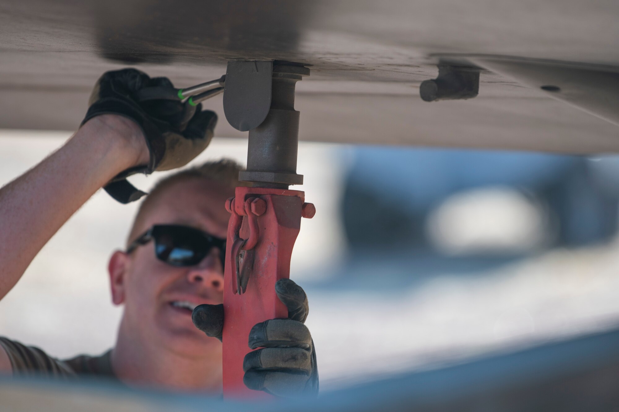 Close up of an Airmen disconnecting the wing stand on an aircraft static display.