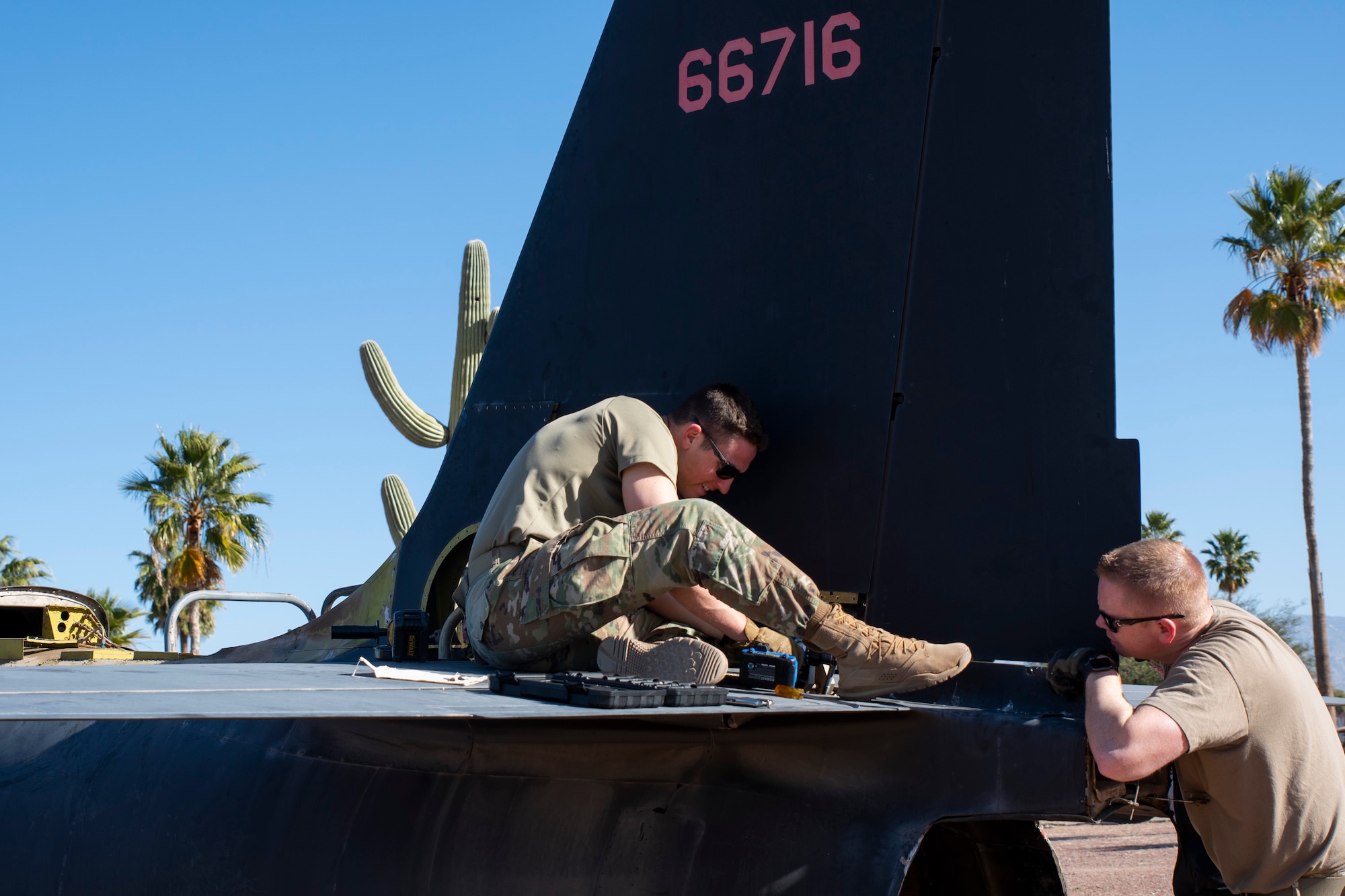 Two Airmen are working on an aircraft.