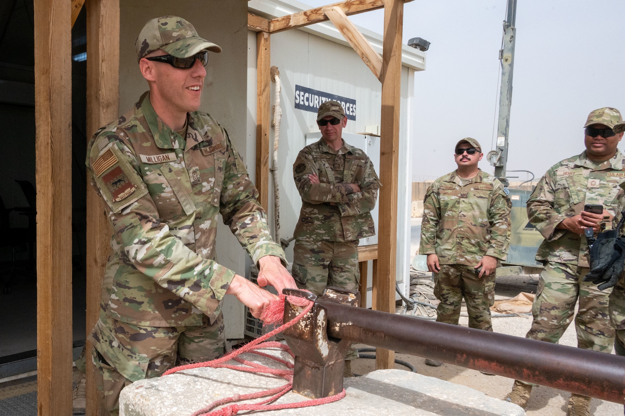 U.S. Air Force Chief Master Sgt. Sean M. Milligan, 332d Air Expeditionary Wing command chief, secures a controlled entry point gate while visiting 332nd Expeditionary Security Forces Squadron Airmen at an undisclosed location in Southwest Asia, April 23, 2022. Chief Milligan's immersion visits give him a better understanding of the unique skillsets every Airman brings to the 332d AEW Red Tail team. (U.S. Air Force photo by Tech. Sgt. Lauren M. Snyder)