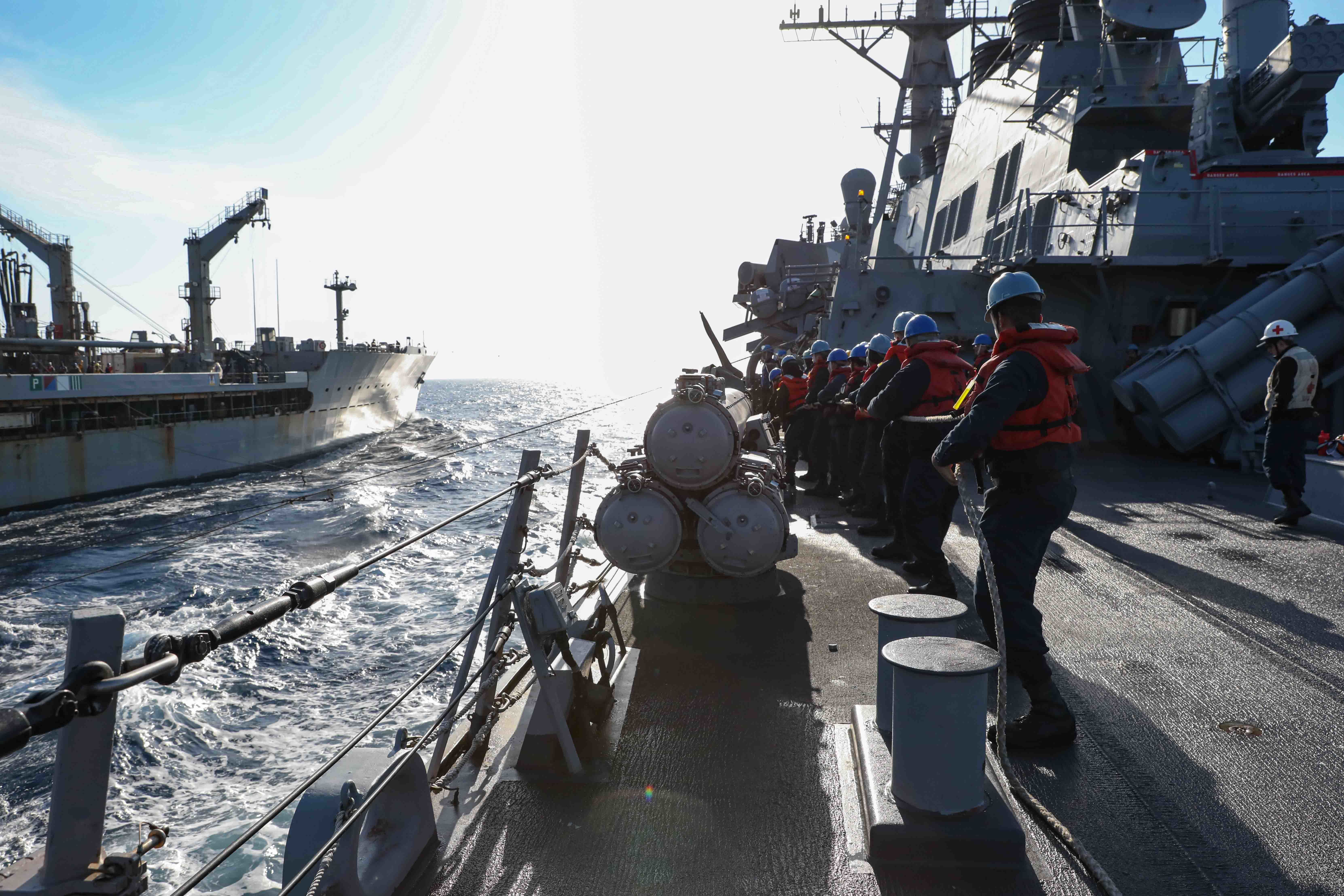 Sailors heave in a line to commence refueling during a replenishment-at-sea with the Military Sealift Command Henry J. Kaiser-class underway replenishment oiler USNS Laramie (T-AO 203)