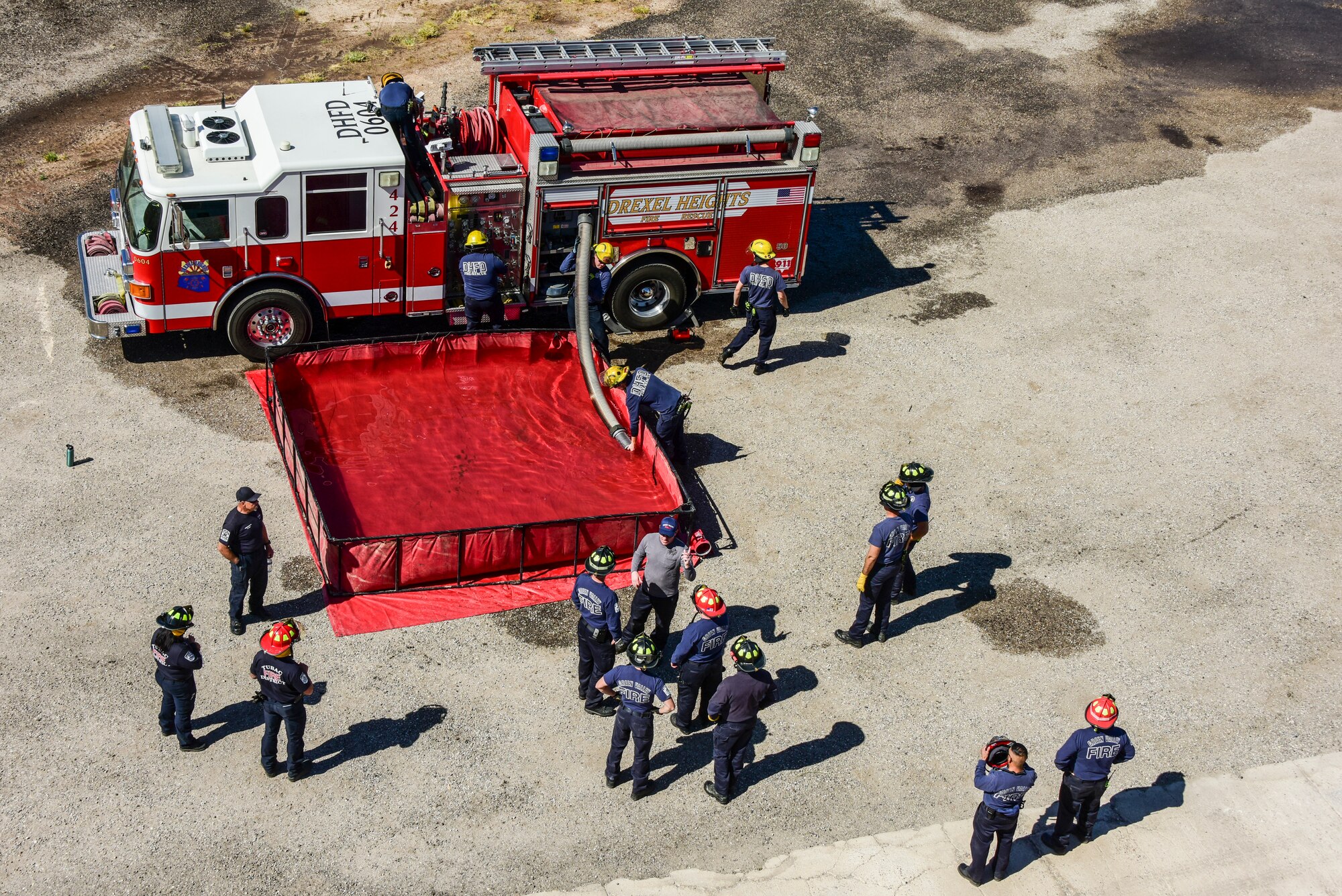 A photo of firefighter filling a portable water tank.