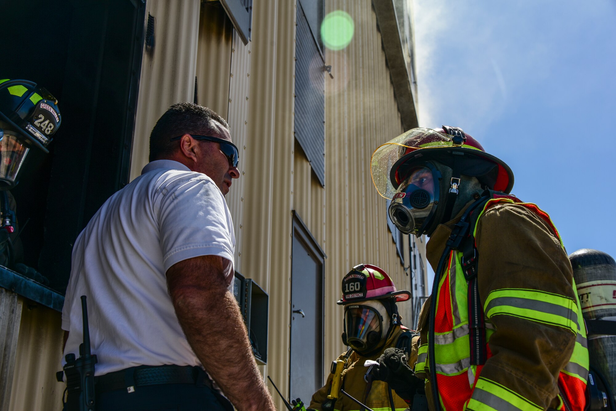 A photo of a fire chief and firefighter speaking to each other.
