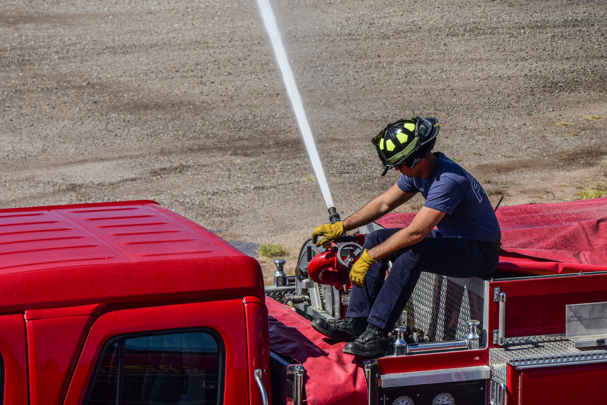 A photo of a firefighter spraying a hose.