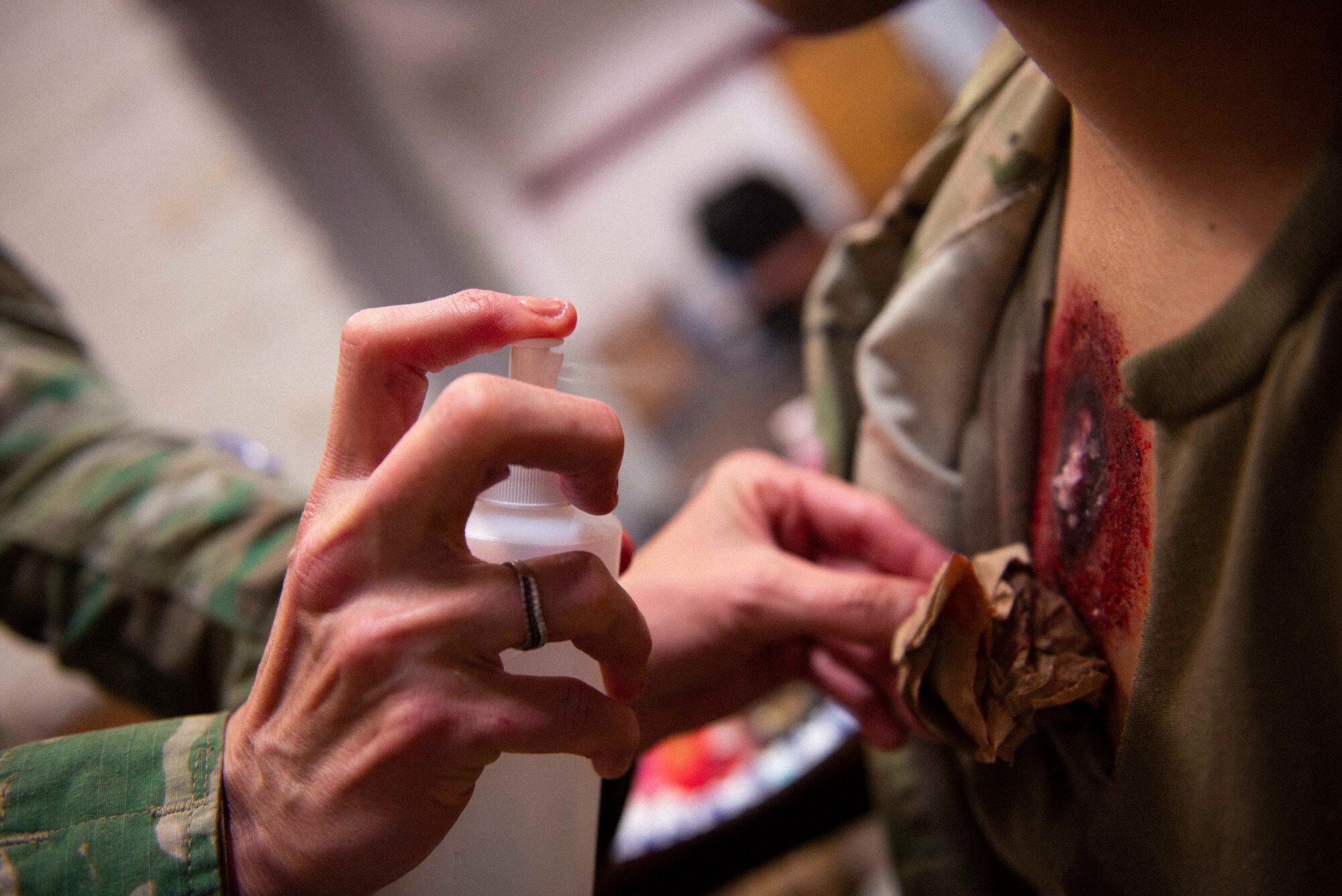 Maj. Deanna Jensen, a clinical nurse with the 934th Aeromedical Staging Squadron, sprays water on a crushed Alka-Seltzer tablet sprinkled on an imitation sucking chest wound on April 7, 2022, at Volk Field Air National Guard Base, Wis. The mixture of the water and crushed tablet produces red bubbles to simulate blood loss during a mass casualty training exercise supporting Viking Shield.  (U.S. Air Force photo by Chris Farley)