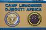 The sign at the main gate of Camp Lemonnier, Djibouti (CLDJ) shows everyone who enters base the seal of CLDJ and of Commander, Navy Region Europe, Africa, Central. CLDJ serves as an expeditionary base for U.S. military forces providing support to ships, aircraft, and personnel that ensure security and stability throughout Europe, Africa and Southwest Asia.