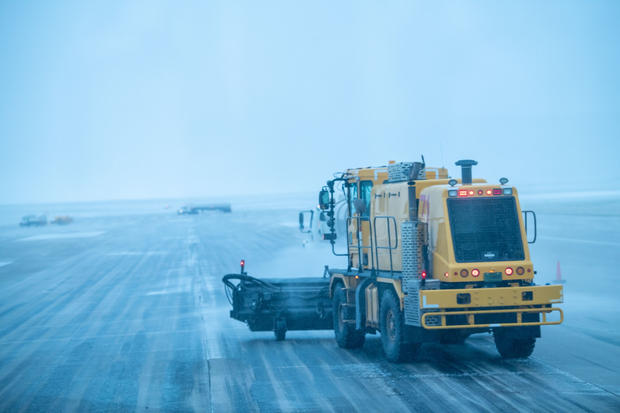 Members of the 28th Civil Engineering Squadron Dirt Boyz unit use Oshkosh H-series trucks with front-mounted sweepers to scrub rubber off the runway of Ellsworth Air Force Base, S.D., April 24, 2022. Rubber must be removed from the runway to ensure sufficient traction for aircraft as they land at Ellsworth. (U.S. Air Force photo by Airman 1st Class Adam Olson)