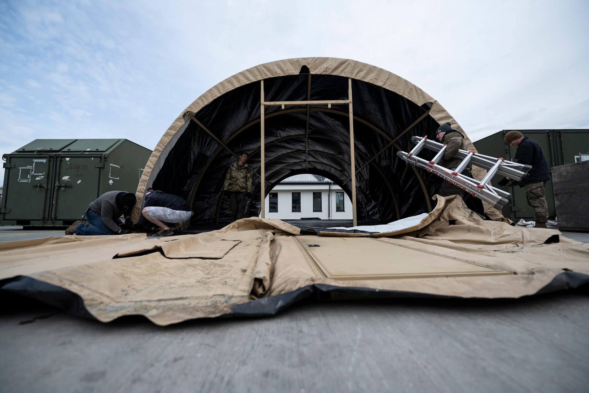 Airmen construct a tent.