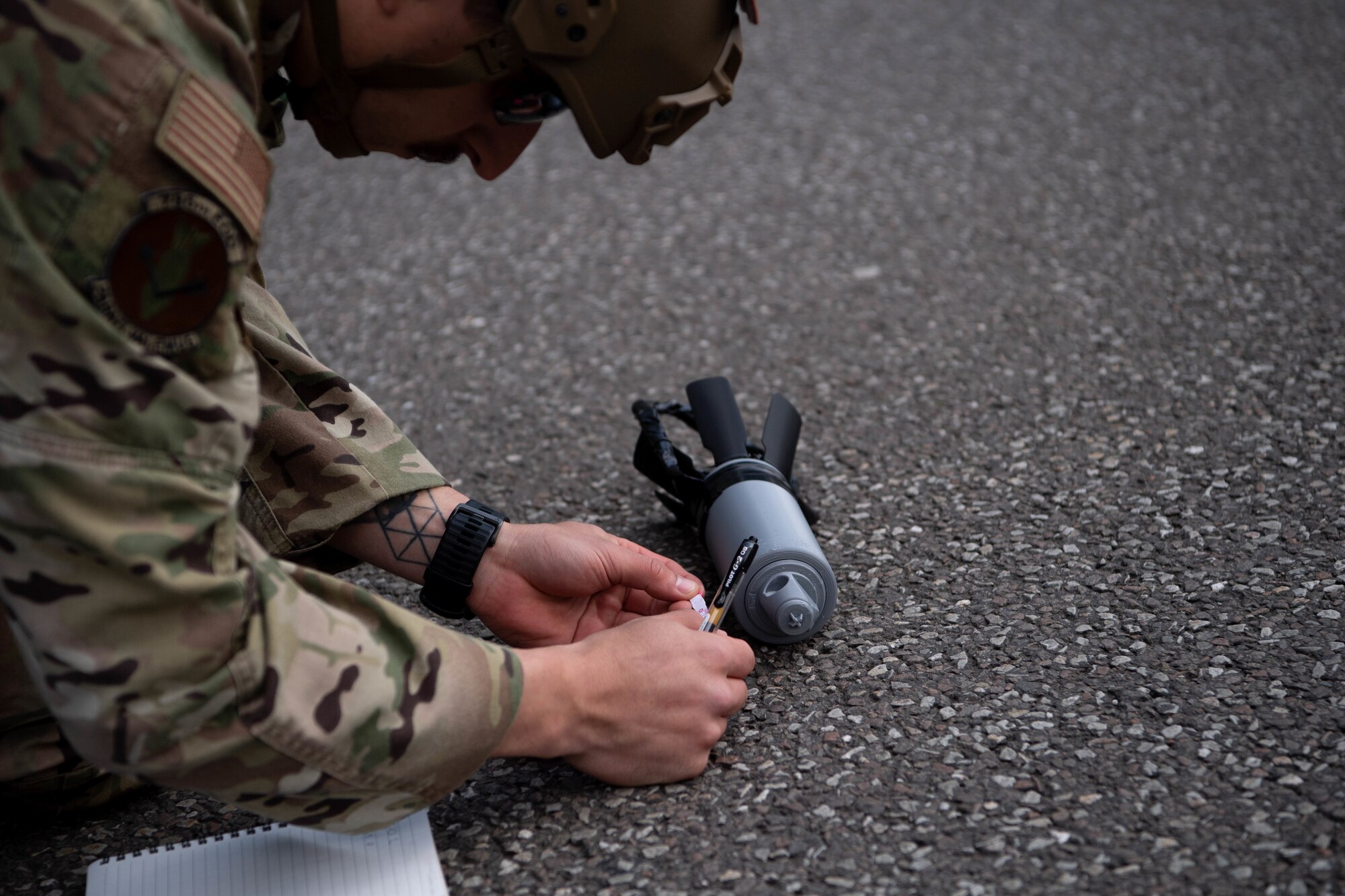 Airman takes measurements of an explosive ordnance prop.