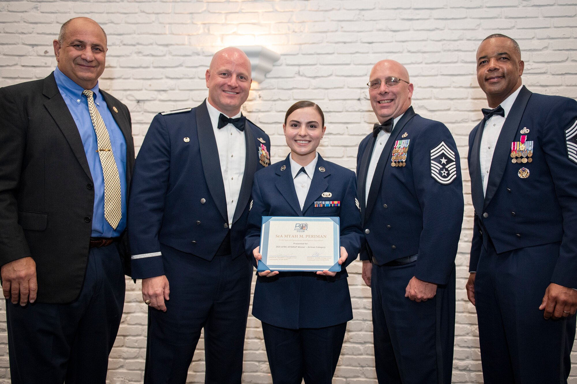 Group photo with award winner and senior leadership holding certificate