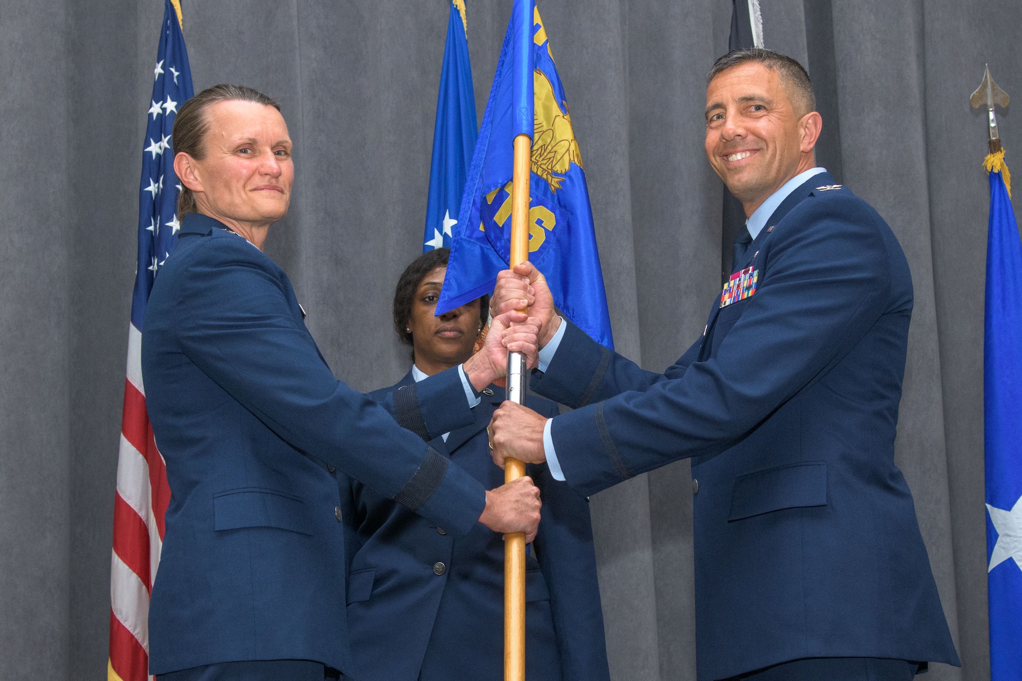 Brigadier Gen. Leslie A. Maher presents the Officer Training School guidon to Col. Keolani W. Bailey during the OTS change of command ceremony, April 21, 2022, Maxwell Air Force Base, Alabama. Maher is the commander of the Jeanne M. Holm Center for Officer Accessions and Citizen Development. Before taking command of OTS, Bailey served as the school’s vice commandant. (U.S. Air Force photo by Trey Ward)