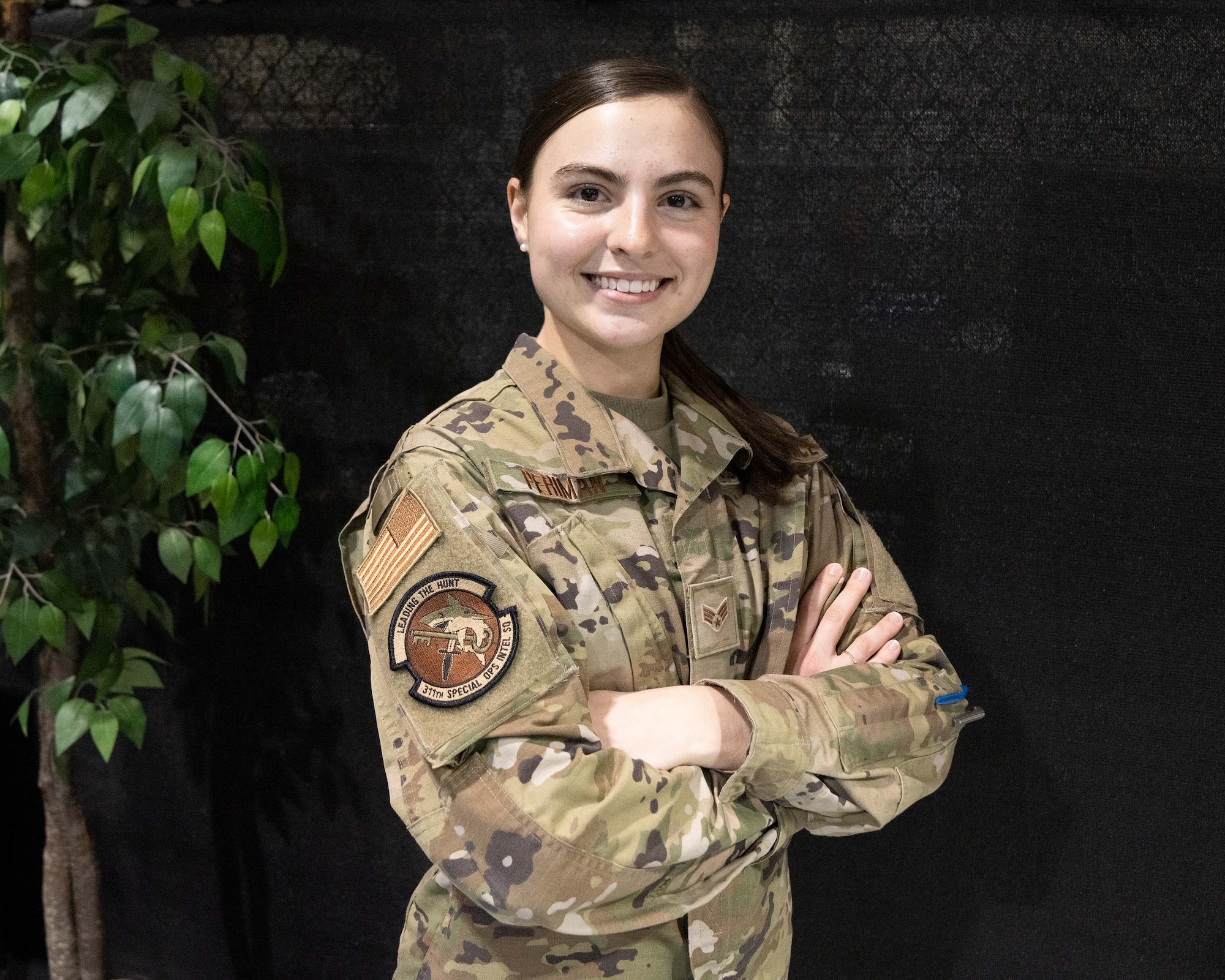 Airman smiles and poses with arms crossed after receiving 2022 Outstanding Airman of the Year award.