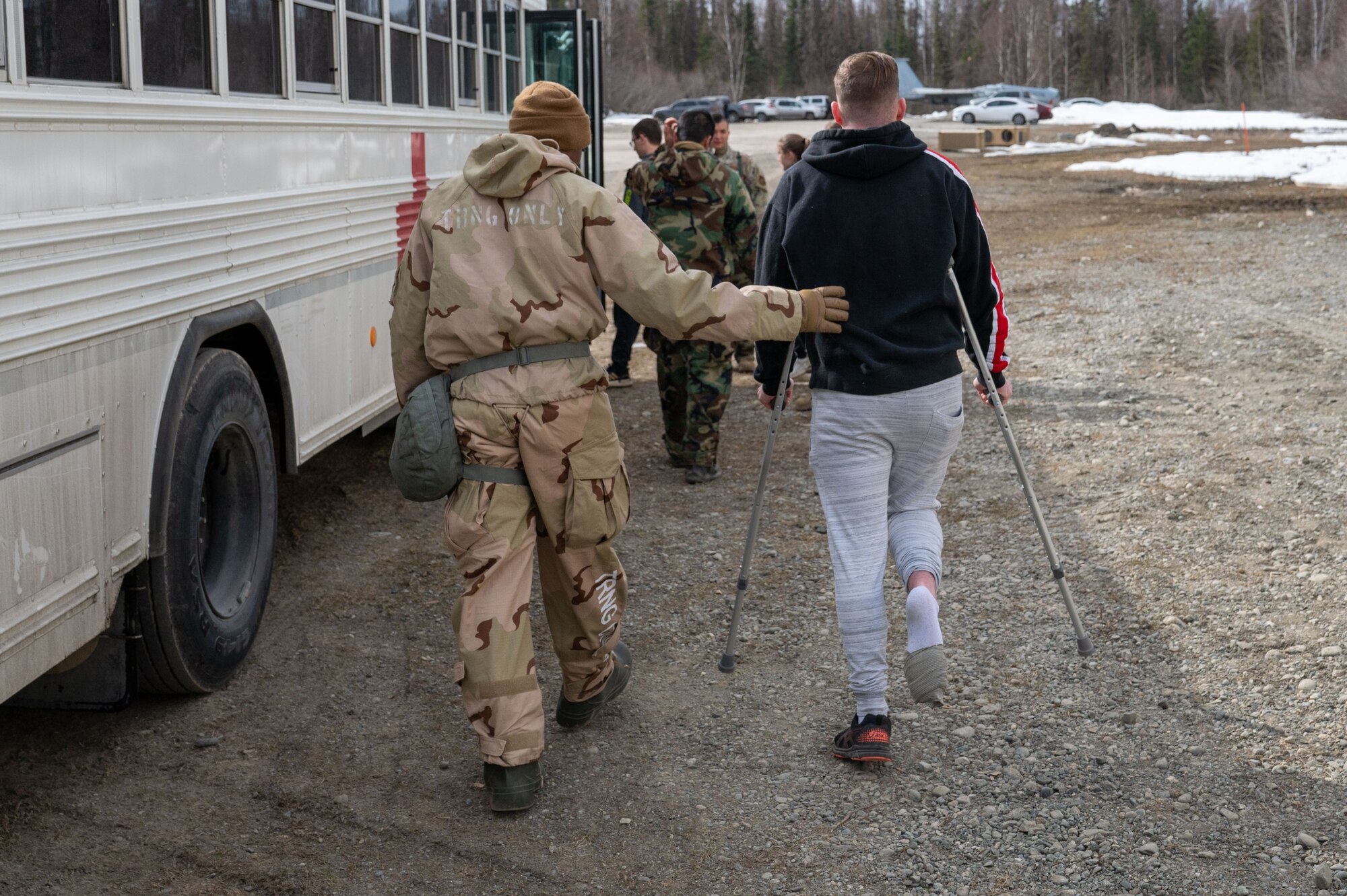 A photo of Tech. Sgt. Luvens Rorshack as he helps a simulated patient onto an ambulance bus.