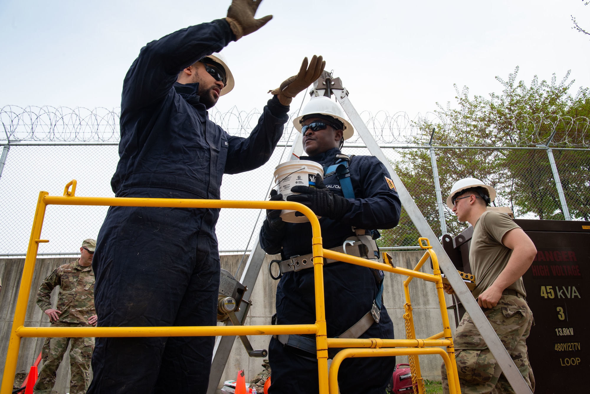 Tech. Sgt. Hilario Silverio, 51st Civil Engineer Squadron electrician, demonstrates to Senior Airman Jayrell Norfleet, 51st CES electrical systems journeyman, how to pull a cable into a confined space to provide a lighting source at Osan Air Base, Republic of Korea, April 21, 2022.