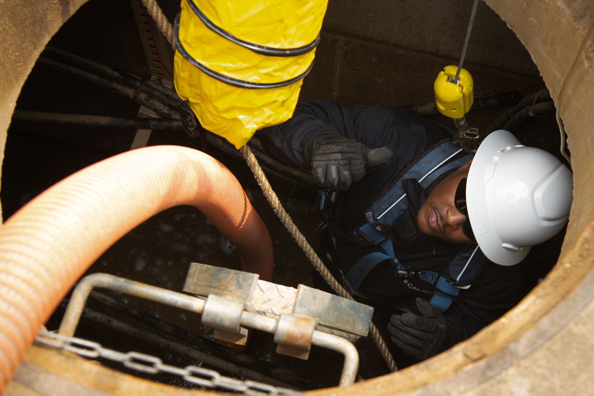 Senior Airman Jayrell Norfleet, 51st Civil Engineer Squadron electrical systems journeyman, enters a confined space to guide electrical wiring underground at Osan Air Base, Republic of Korea, April 21, 2022.