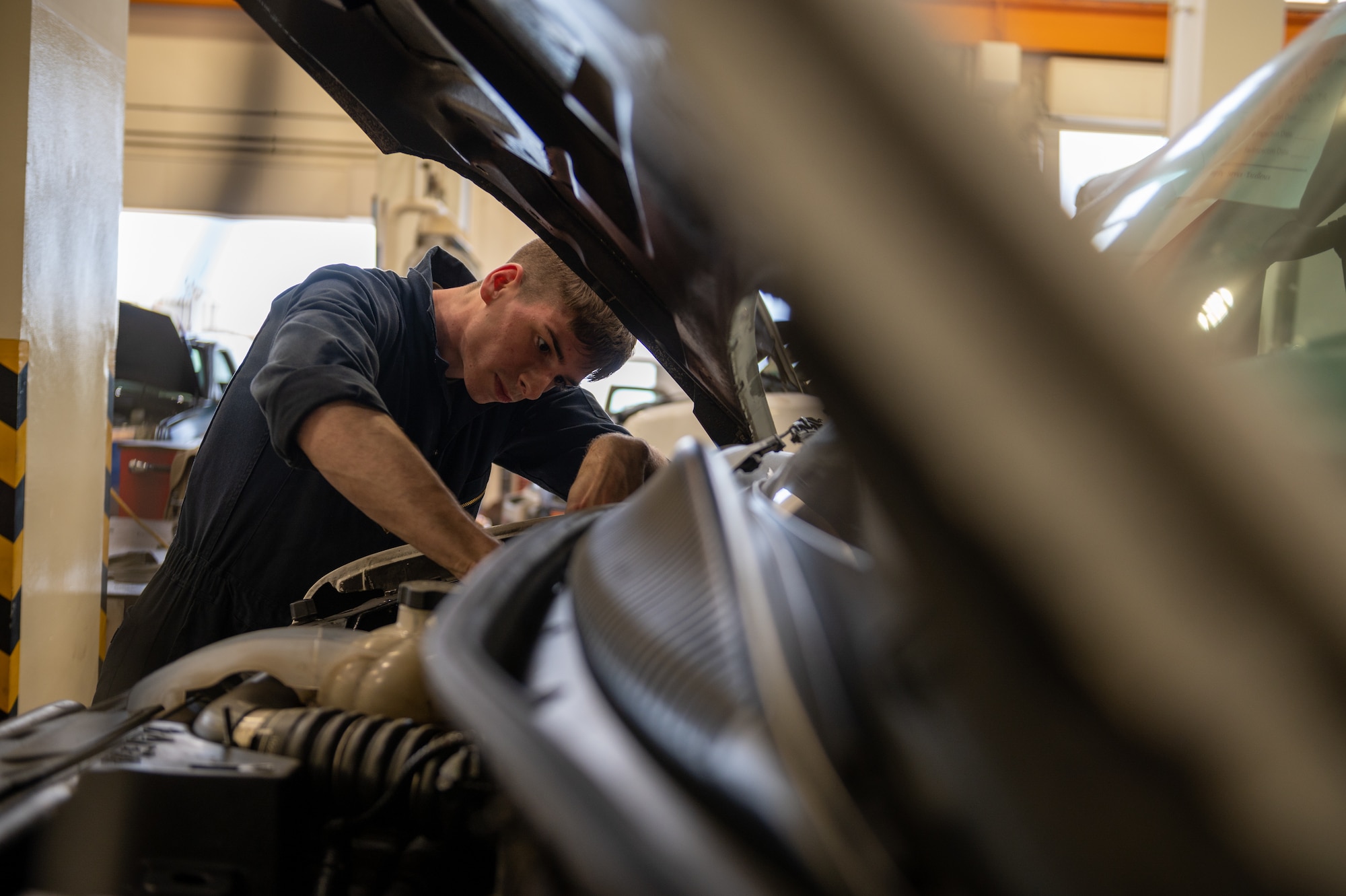 Airman performs maintenance on a vehicle