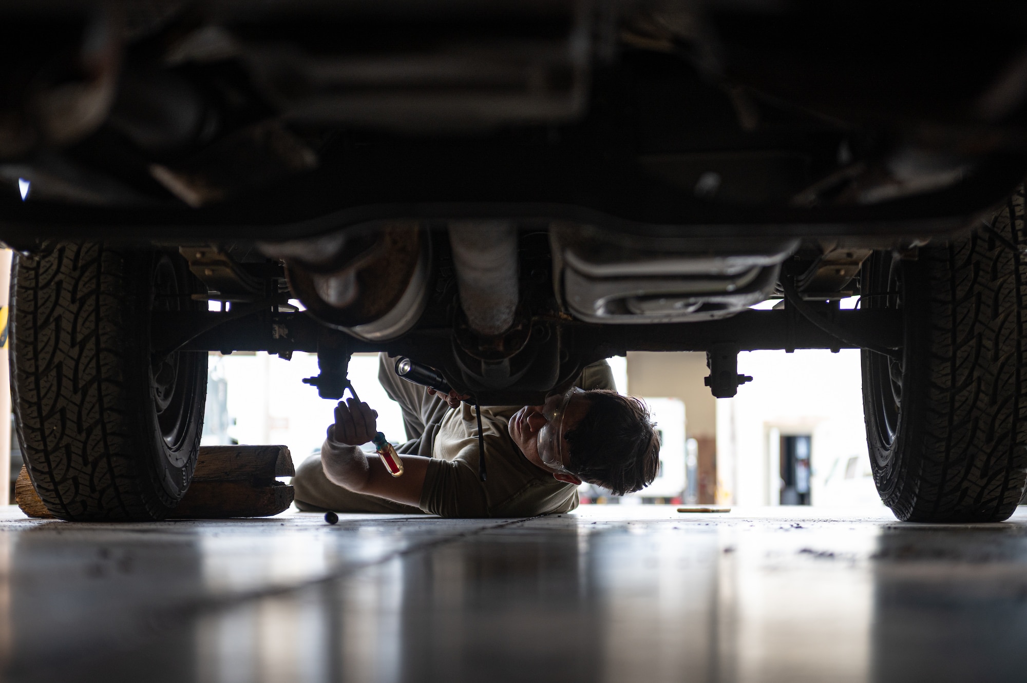 Airman inspecting truck undercarriage