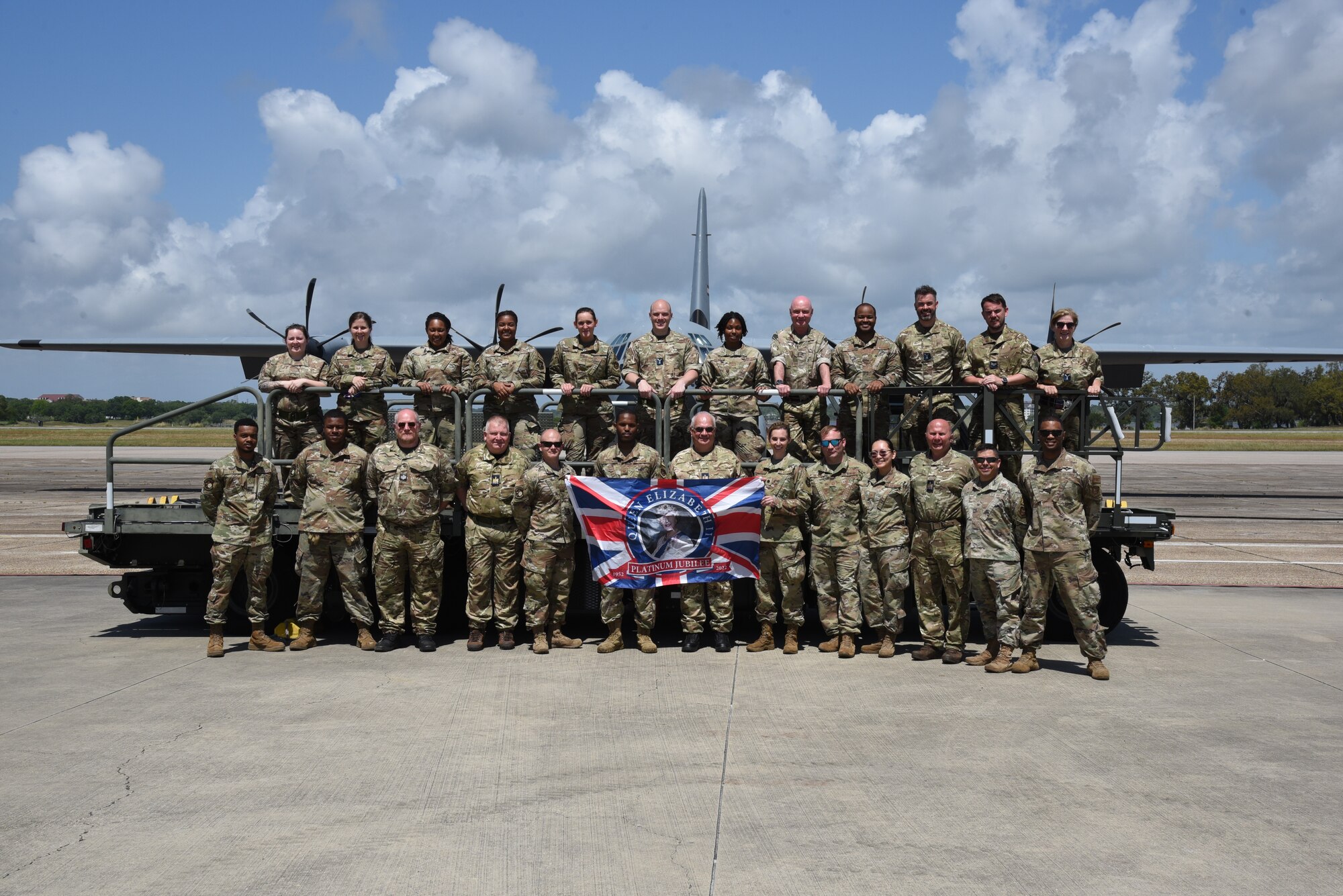 Group photo of all members of the British Royal Air Force Reserve 4624th Squadron and the 41st Aerial Port Squadron members that were present during the visit on and in front of a K-loader.