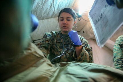 U.S. Navy Hospital Corpsman Irene Avila with 1st Medical Battalion, 1st Marine Logistics Group, I Marine Expeditionary Force, checks the breathing of a simulated patient during a Marine Corps Combat Readiness Evaluation exercise on Camp Pendleton, California, April 9, 2022. 1st Medical Battalion performed a MCCRE in order to assess unit effectiveness and readiness. (U.S. Marine Corps photo by Lance Cpl. Bradley Ahrens)