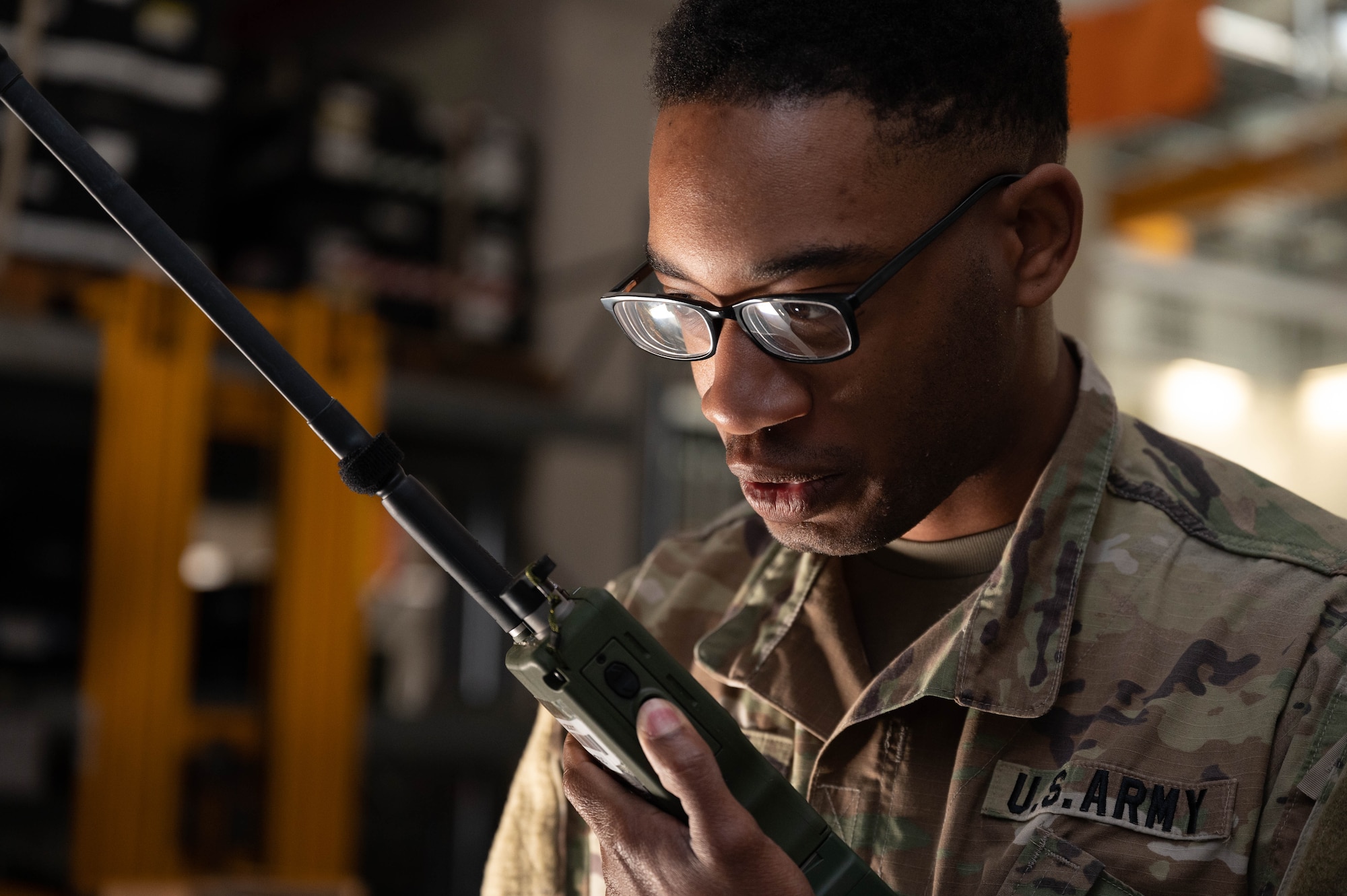U.S. Army soldier speaks with teammates on a radio.