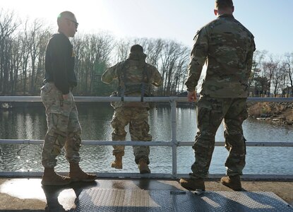 A blindfolded Pennsylvania National Guard Soldier leaps from the pier during the combat water survival test of the Ranger and Sapper Assessment Program April 22, 2022, at Fort Indiantown Gap, Pennsylvania. Service members had to jump into the water and maintain their weapon and gear while swimming to the shore.