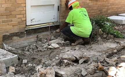 A historically qualified mason reconstructs a section of Building 1’s exterior wall using brick salvaged from a section of the foundation that could not be preserved at Camp Mabry, Texas. Enough original brick was salvaged so that no new brick was needed for repairs.