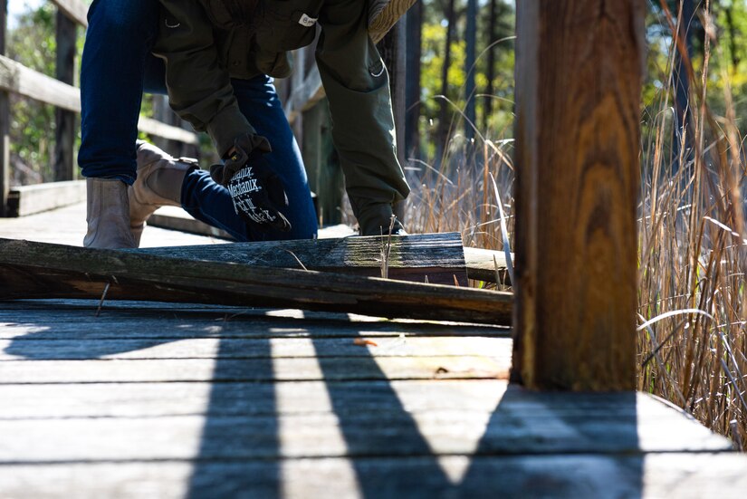 An individual works on a boardwalk.