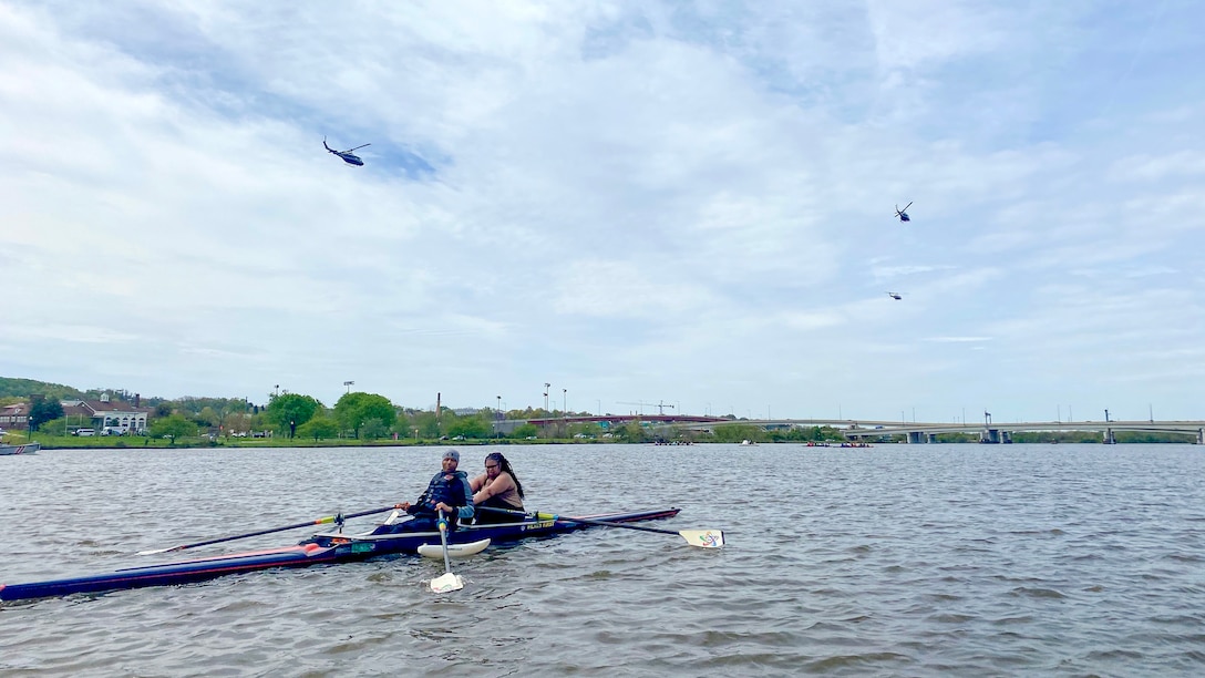 Helicopters fly over rowers during training.