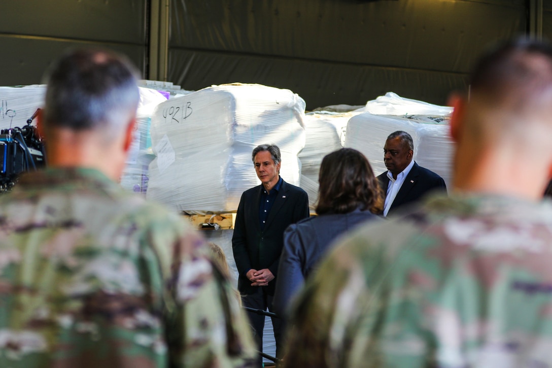 Defense Secretary Lloyd J. Austin III and Secretary of State Antony Blinken stand and speak to a group of people.