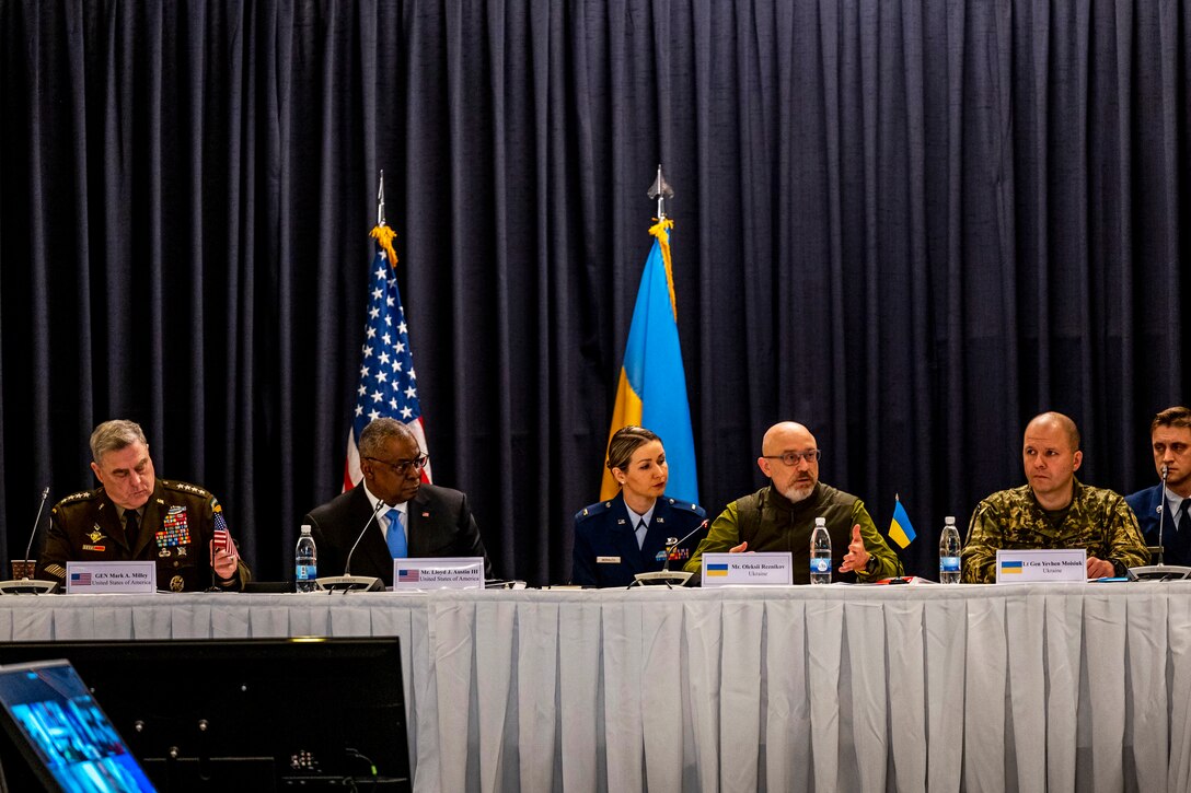 Officials including Secretary of Defense Lloyd J. Austin III and Army Gen. Mark A. Milley sit at table.