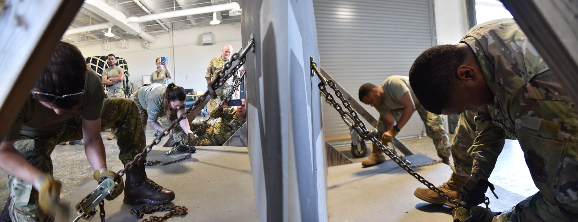 British Royal Air Force members tie down with chains on the left in a competition against the US Air Force members on the right side.