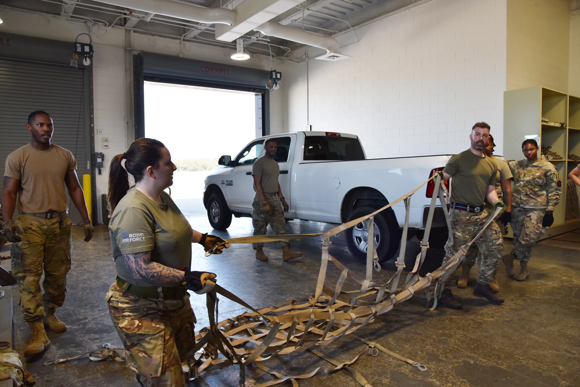 British Royal Air Force Reserve movers prepare to throw a cargo net.