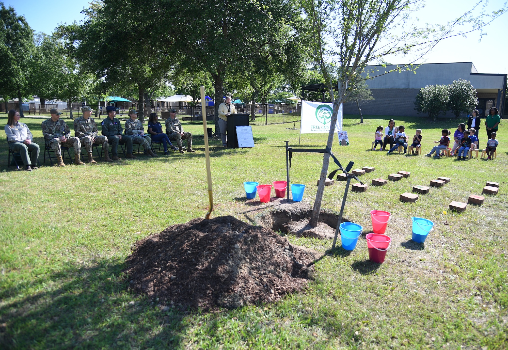 Keesler personnel and children from the Child Development Center attend the Arbor Day Celebration at Keesler Air Force Base, Mississippi, April 28, 2022. A tree planting ceremony and a Tree City USA flag presentation took place at the event. (U.S. Air Force photo by Kemberly Groue)