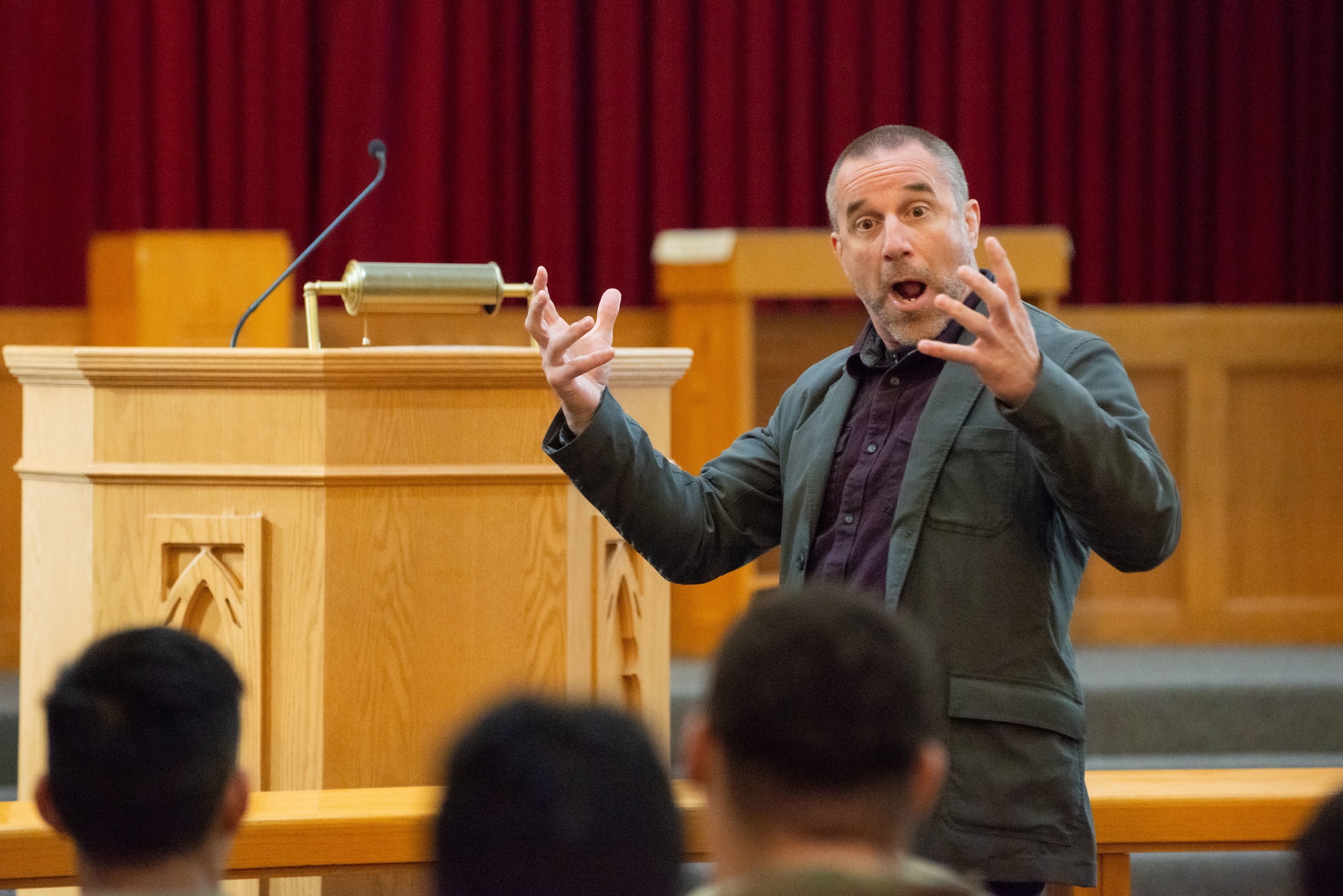 A photo of a man speaking to a group of soldiers