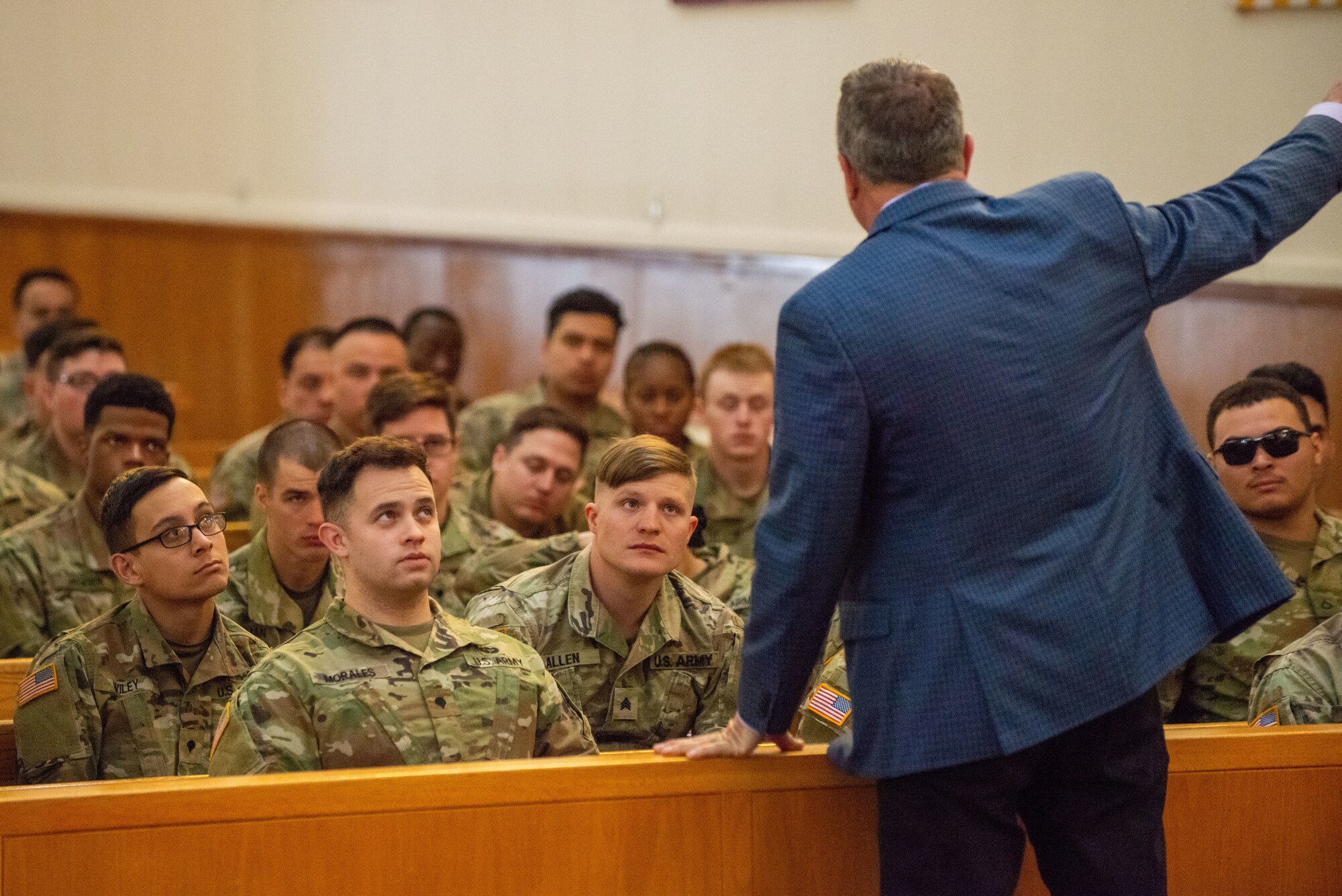 A photo of a man speaking to a group of soldiers