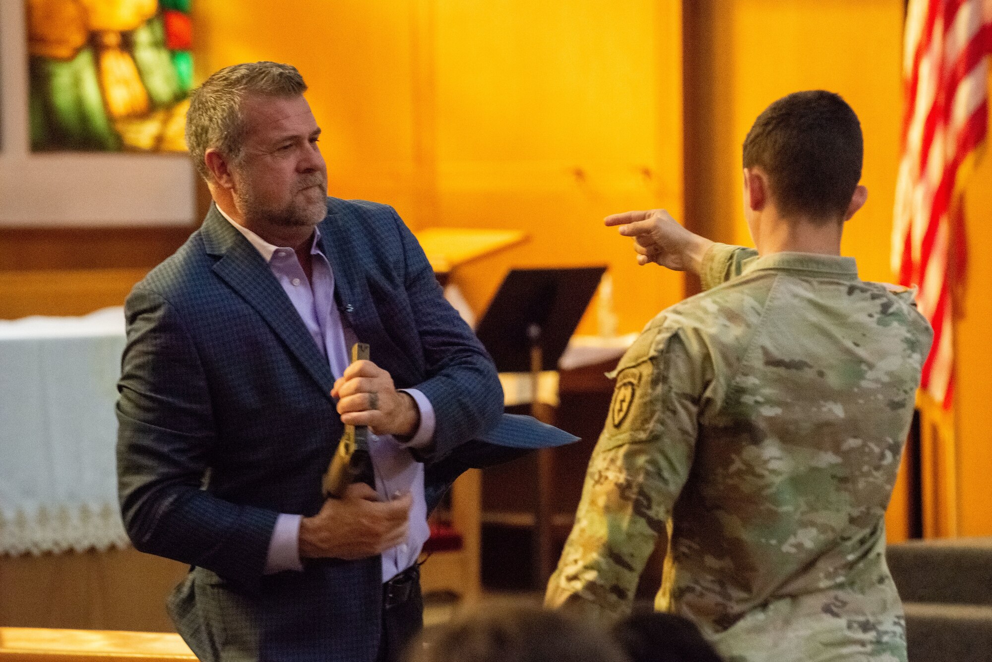 A photo of two men demonstrate a gun disarming technique