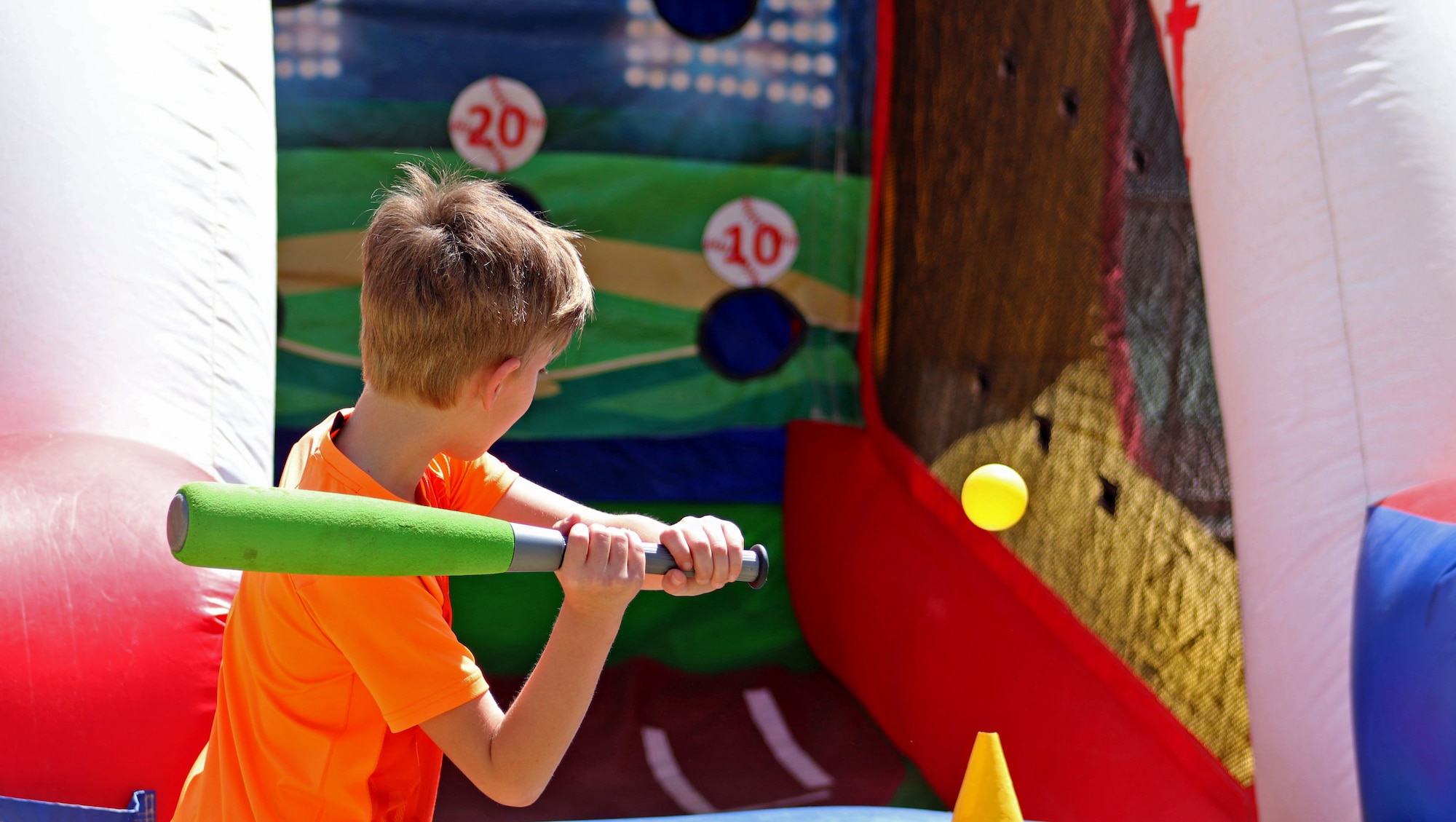 A photo of a child about to hit a ball.