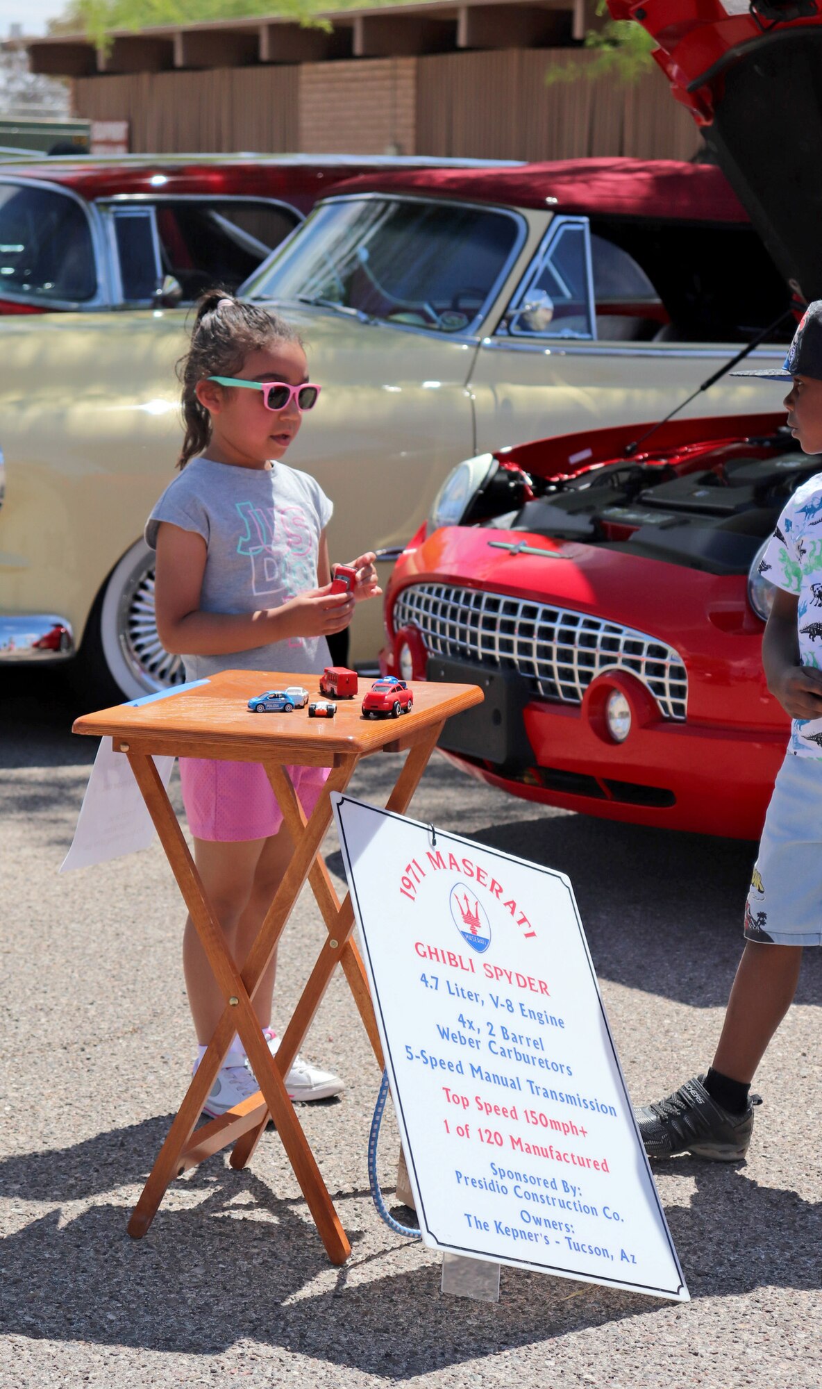 A photo of children at a car show.