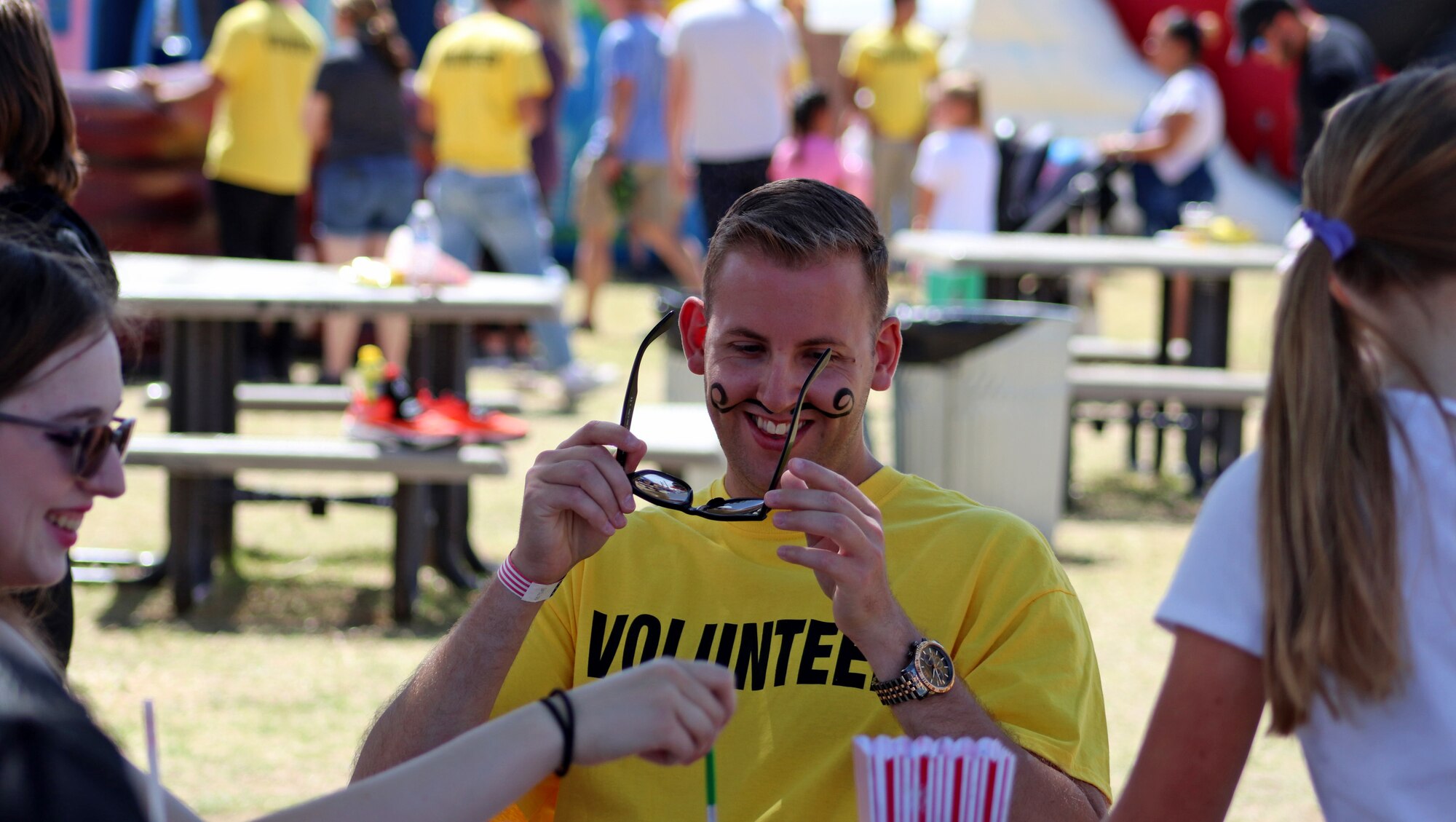 A photo of a man putting his glasses back on.