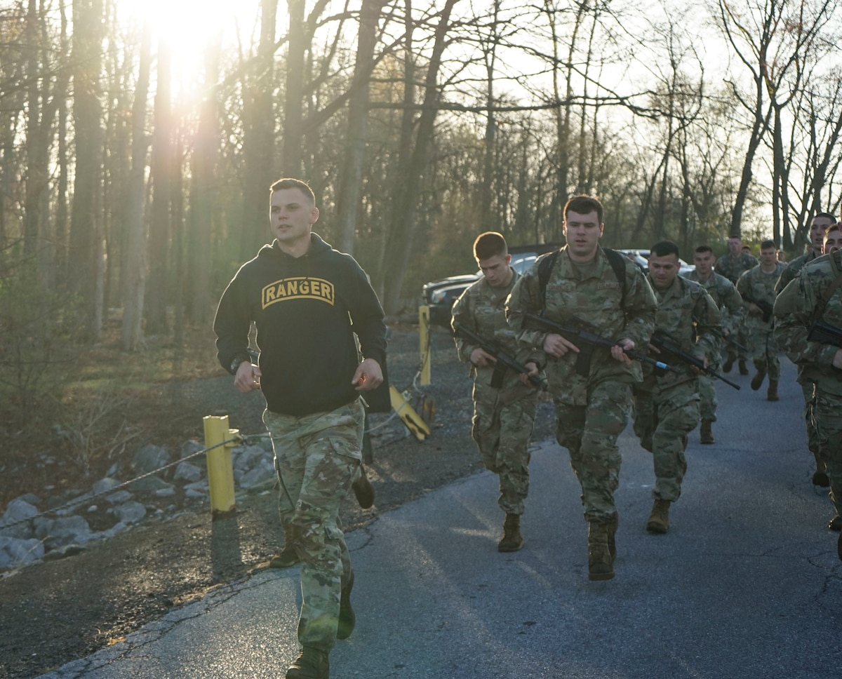 Staff Sgt. Paul Almquist, left, a Ranger and Sapper Assessment Program instructor assigned to Pennsylvania Joint Force Headquarters, leads participants in a run to the Marquette Lake for the combat water survival test April 22, 2022. The CWST is one of several events that challenged Soldiers and Airmen physically and mentally to see if they are prepared for Ranger and Sapper School.
