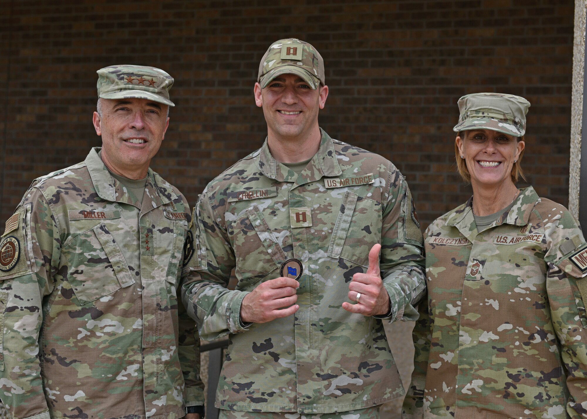 U.S. Air Force Surgeon General Lt. Gen. Robert Miller; Chief Master Sgt. Dawn Kolczynski, Chief, Medical Enlisted Force and Enlisted Corps Chief; and Capt. Caleb Chiellini, 17th Medical Group laboratory flight commander; pose for a photo at Goodfellow Air Force Base, Texas, April 26, 2022. Chiellini was coined for his exceptional work and dedication to his job as a 17th MDG Airman. (U.S. Air Force photo by Senior Airman Ashley Thrash)